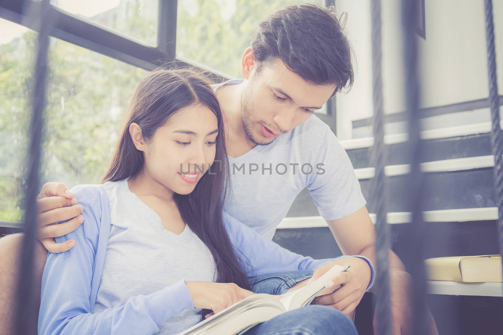 Couple asian handsome man and beautiful woman reading book and smile at home, boyfriend and girlfriend with activities together for leisure, education concept.