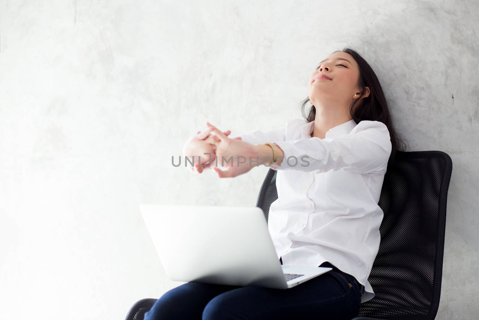Beautiful young asian woman with laptop stretch and exercise relax after work success, modern office with copy space, freelance business concept.