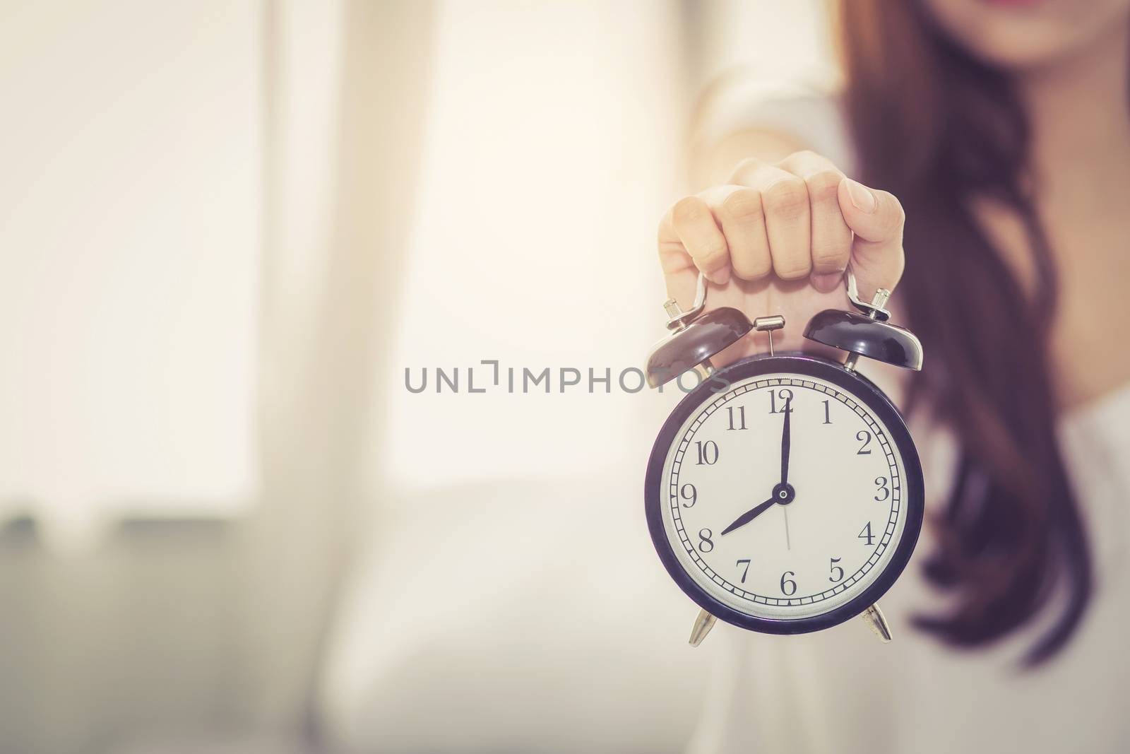 Beautiful asian young woman wake up in morning annoyed alarm clock holding hand, girl hurry wake late with appointment, lifestyle concept.