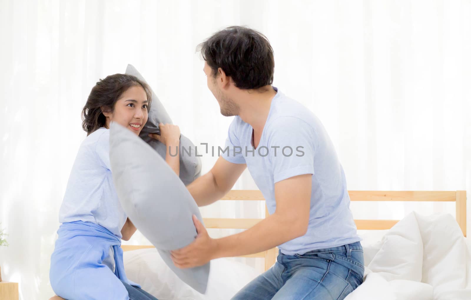 Asian young couple happy fun with playing pillow fight at bedroom, relationship of love concept.