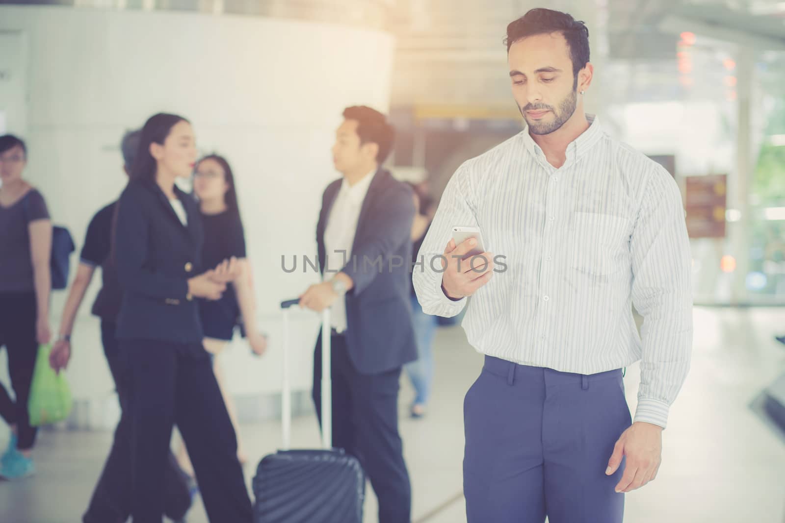 Businessman talking smart mobile phone with working team on background, man standing with confident, business teamwork concept.