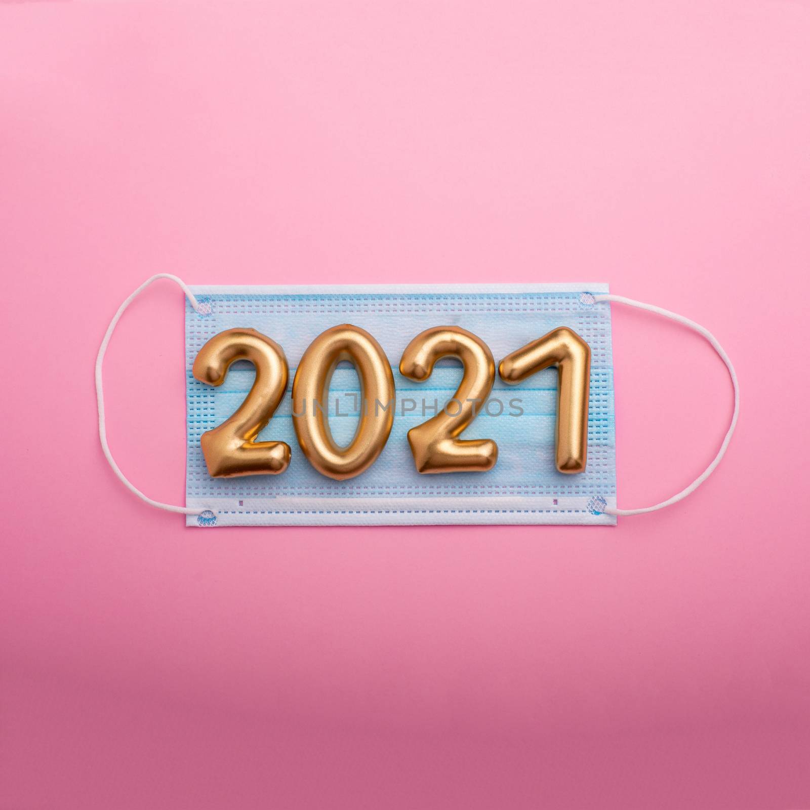 Gold numbers 2021 with face mask on blue background. Happy new pandemic year