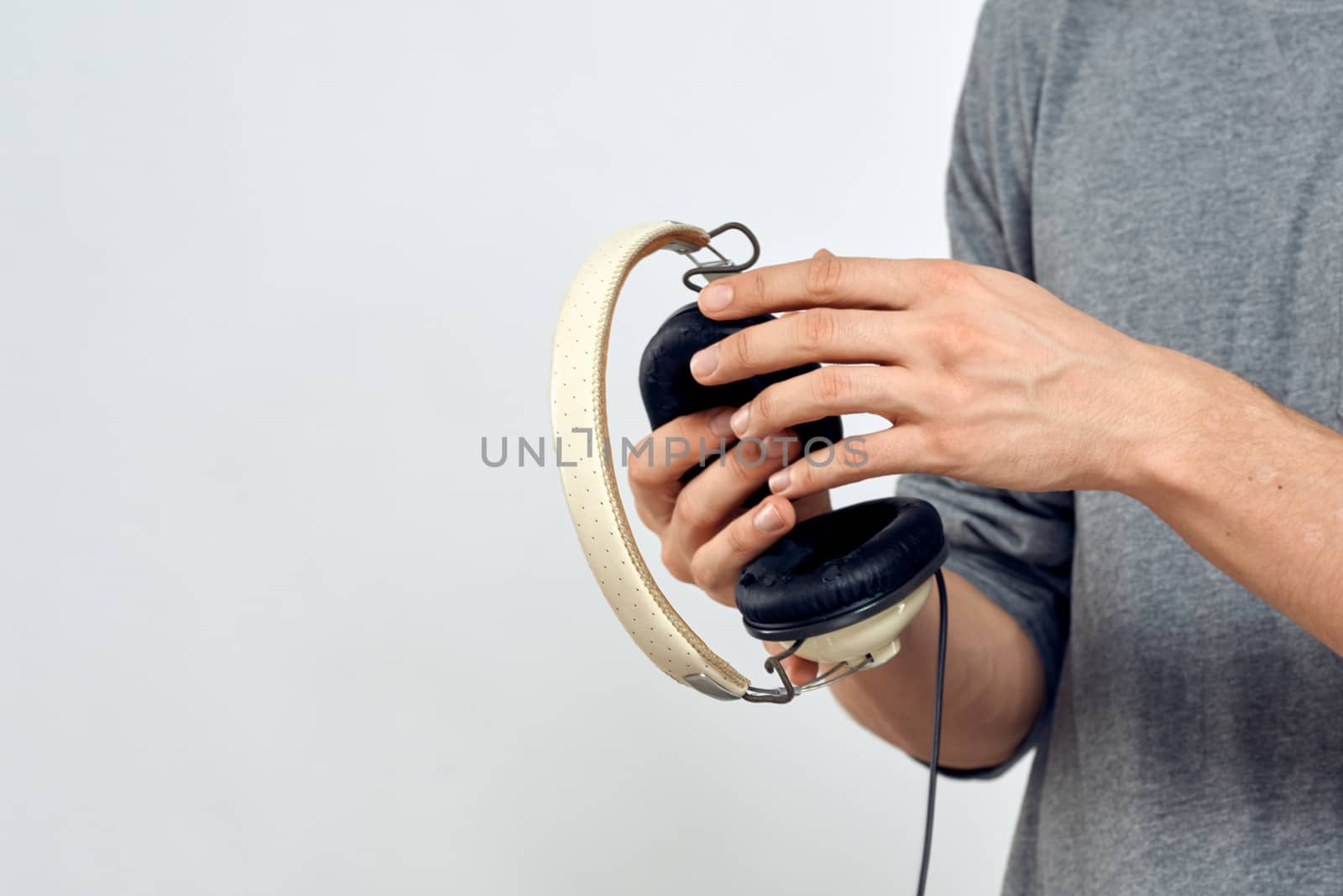 Man holding headphones in the hands of a man lifestyle modern style technology cropped view by SHOTPRIME