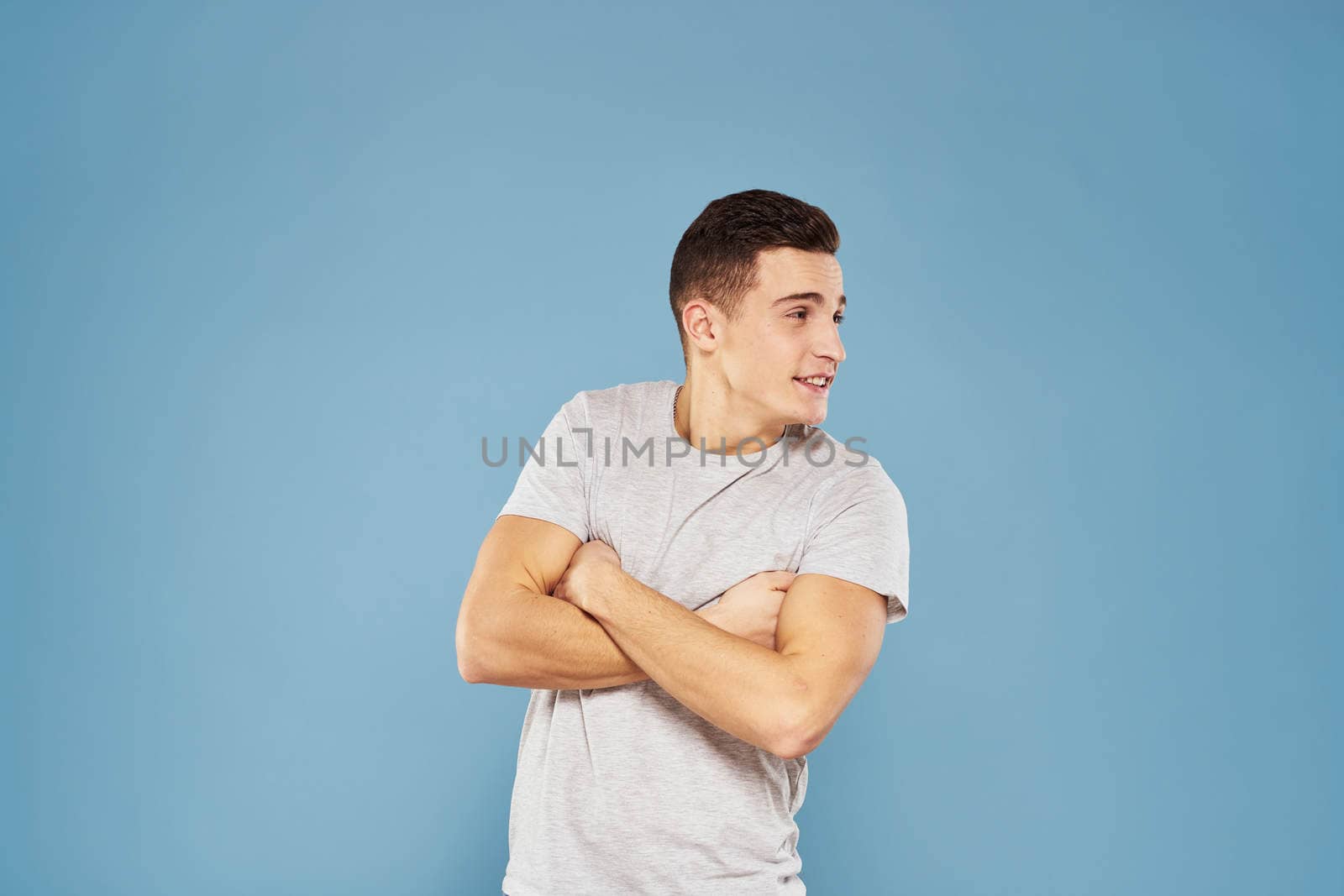 cheerful man in a white t-shirt gesturing with his hands emotions blue background by SHOTPRIME