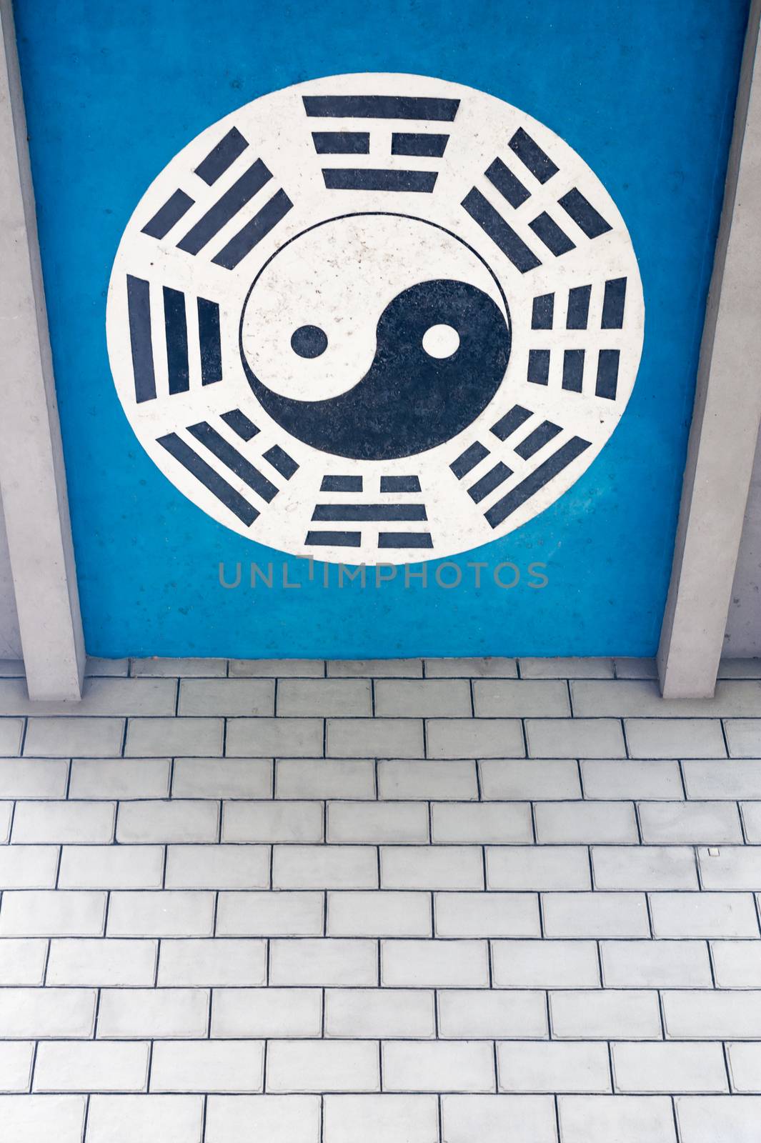 Yin and Yang symbol on a blue background above a brick wall in China