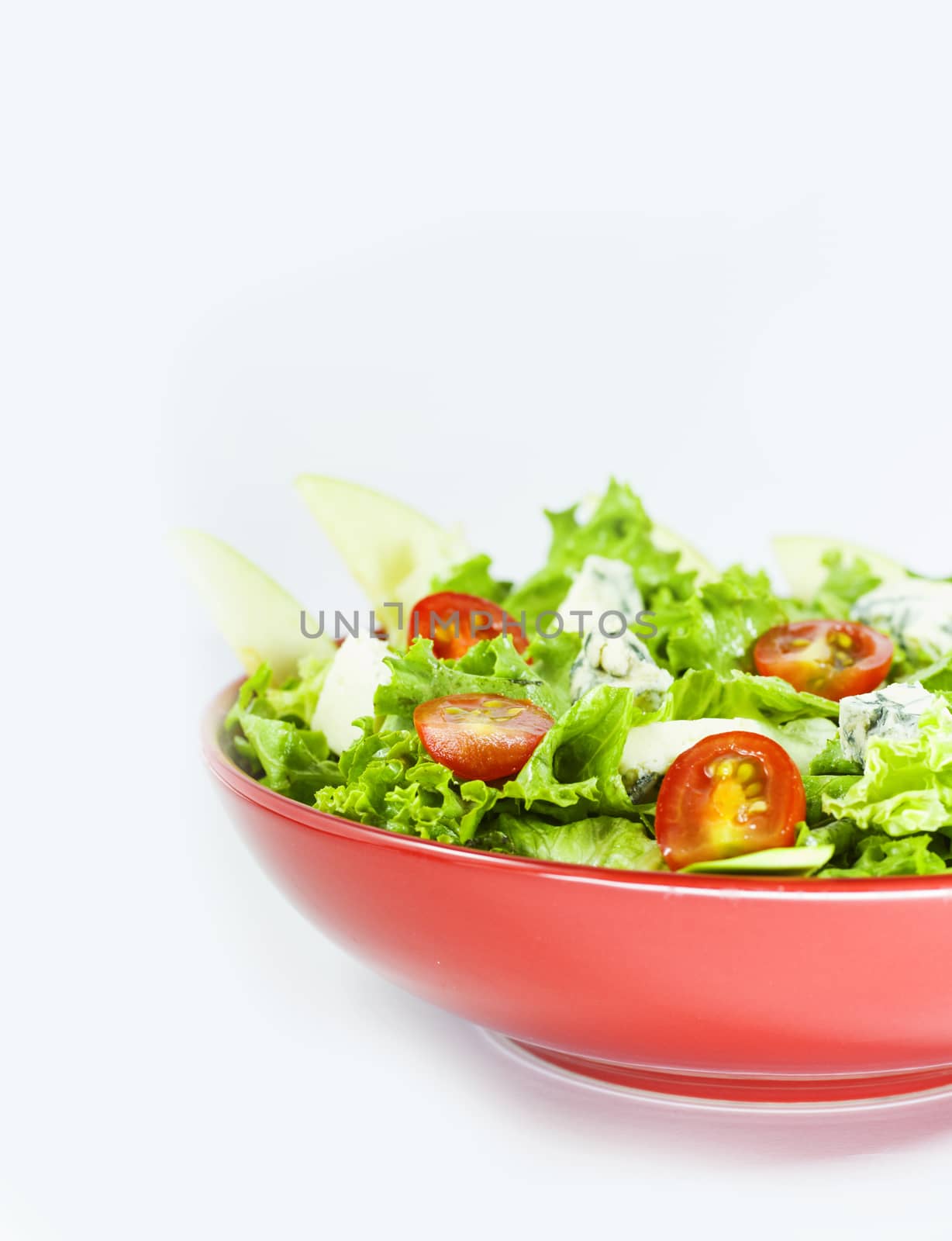 Vegetarian salad with tomatoes, cheese, lettuce. Vegetables in the red bowl. Delishes food.