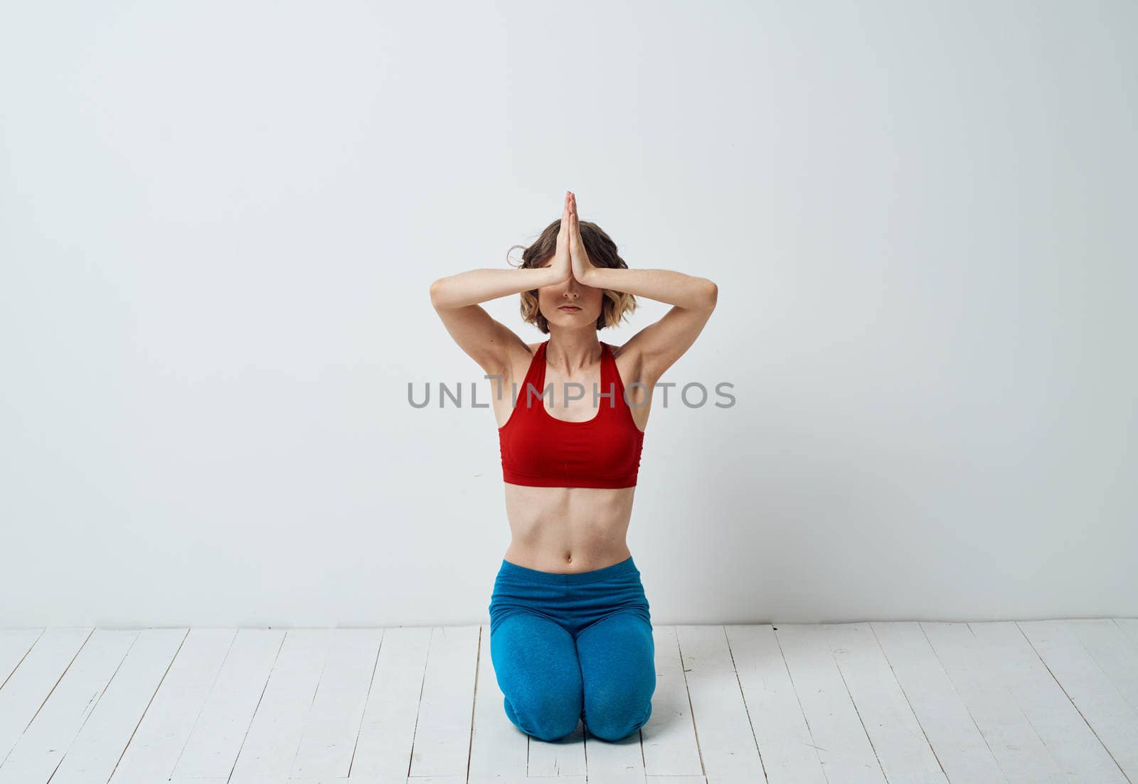 A slender woman is engaged in yoga for beginners on a light background in full growth. High quality photo