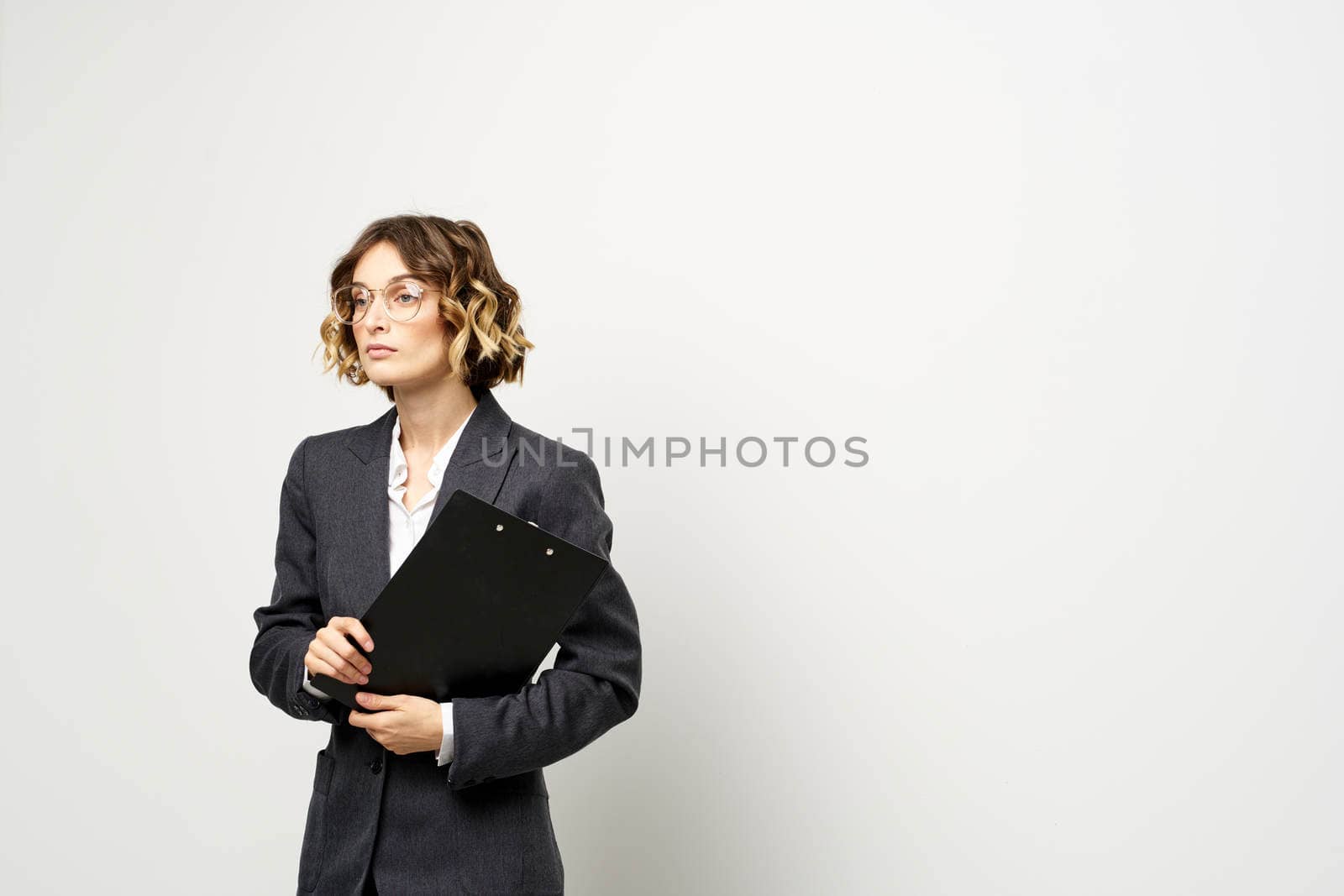business woman in a suit with documents in hands light background curly hair hairstyle. High quality photo