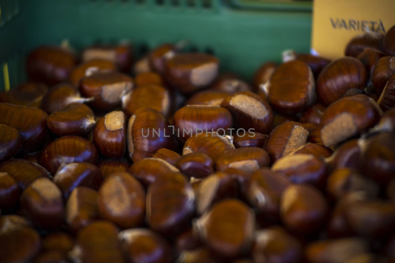 brown chestnuts in a box for sale at the market