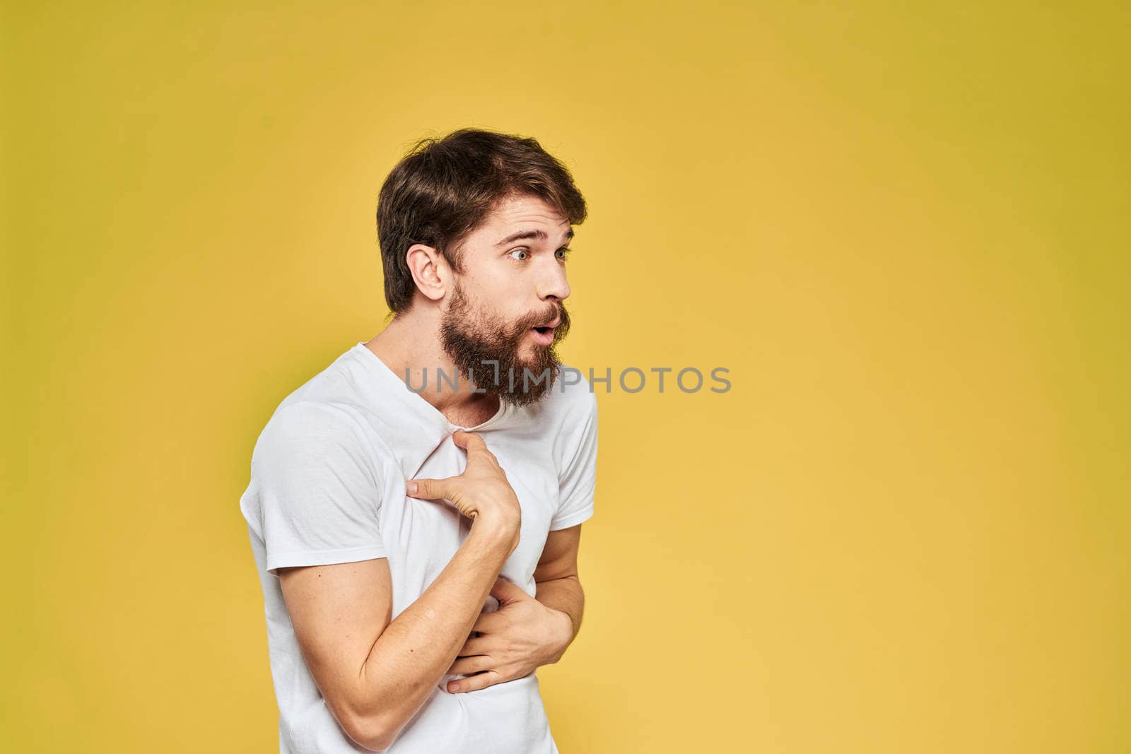 Bearded man in white t-shirt emotions close-up fun yellow background. High quality photo