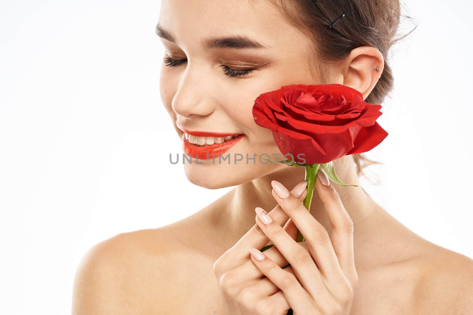 charming brunette girl with makeup on her face and a red rose in her hand. High quality photo