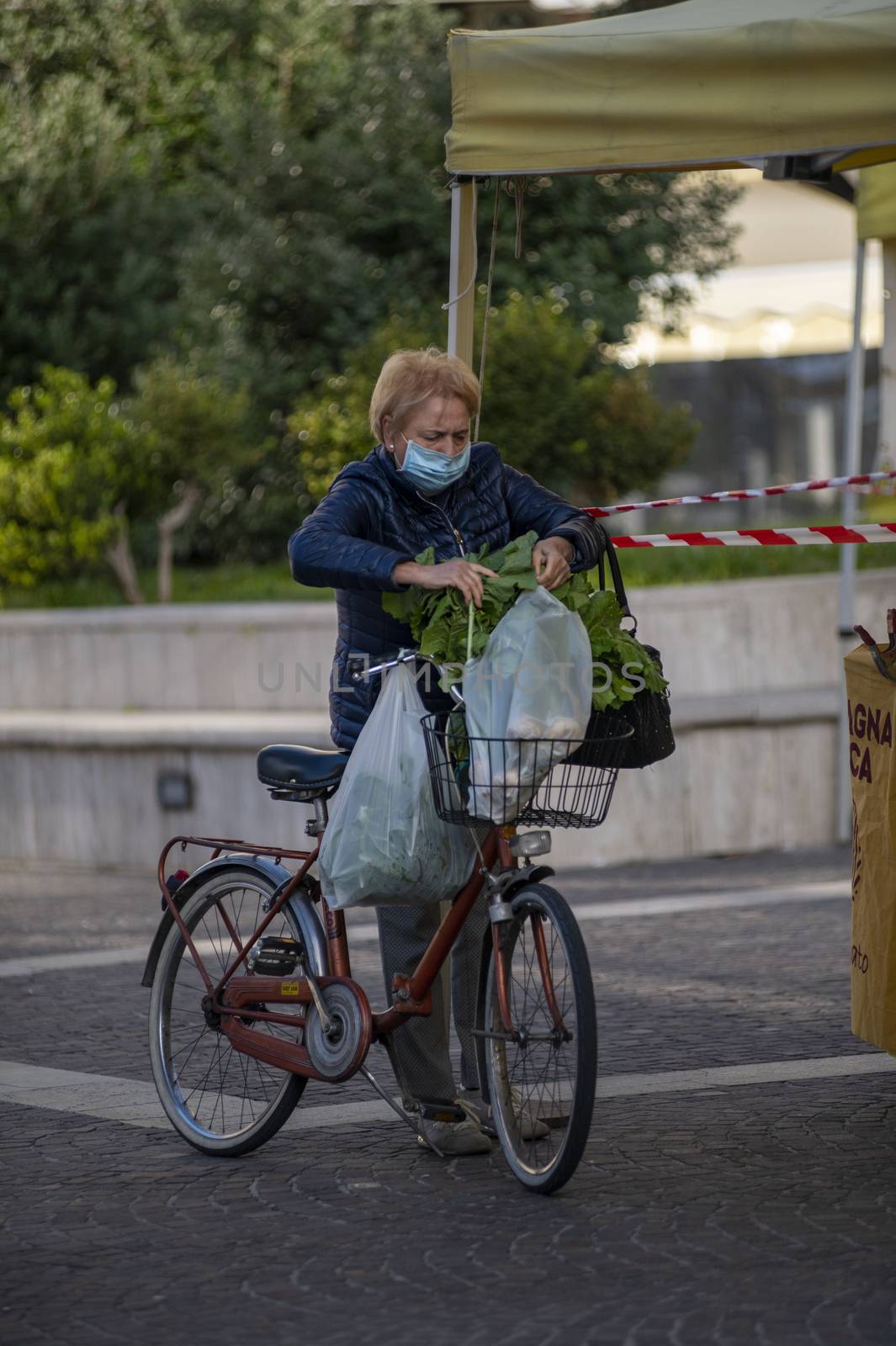 woman holding shopping bags while waxing them on a bicycle by carfedeph