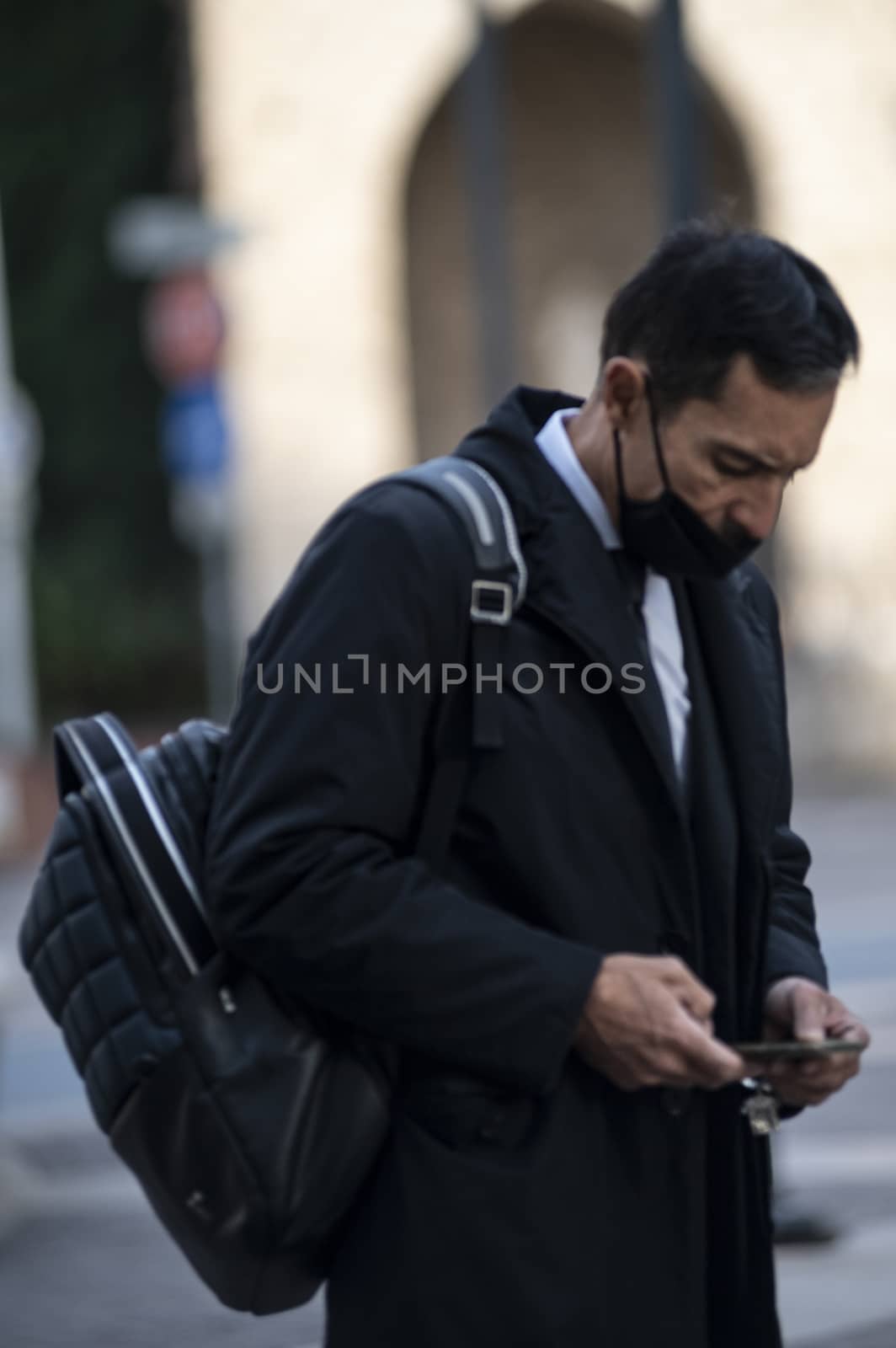 successful man with medical mask and phone by carfedeph