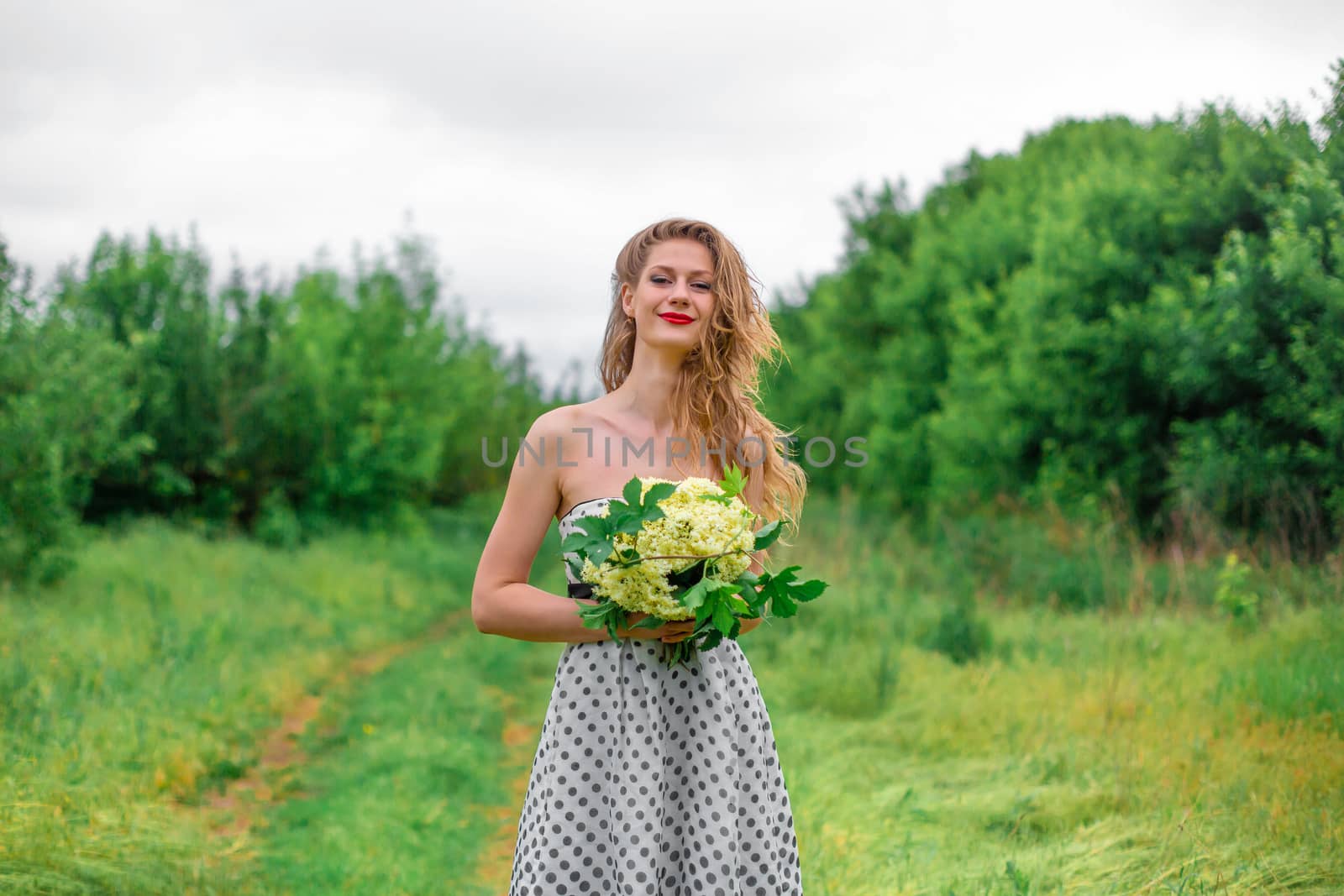 A beautiful young blonde girl collected a bouquet of wildflowers. Enjoy a walk on a warm summer day by Try_my_best