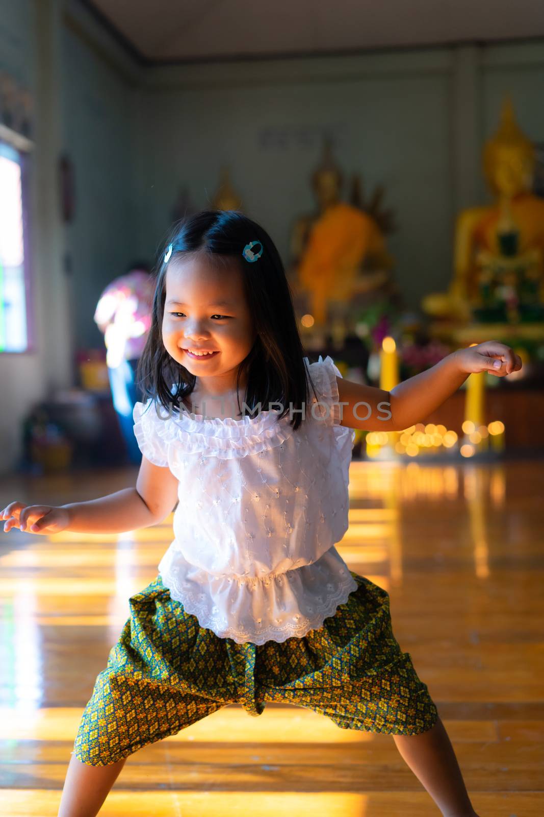 happy asian little girl in Thai period dress in Thai temple by domonite
