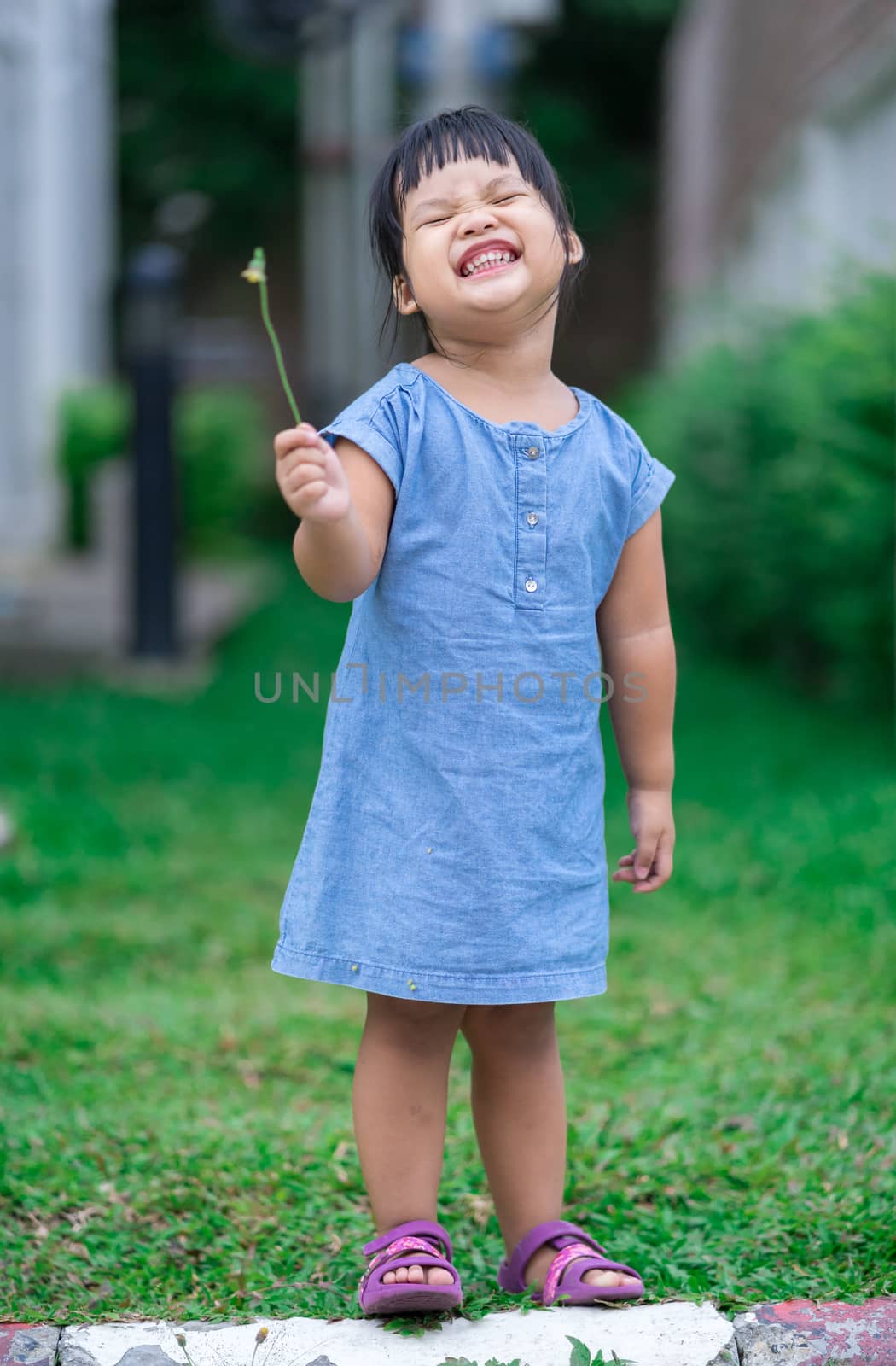 little girl standing in the park and smiling happy