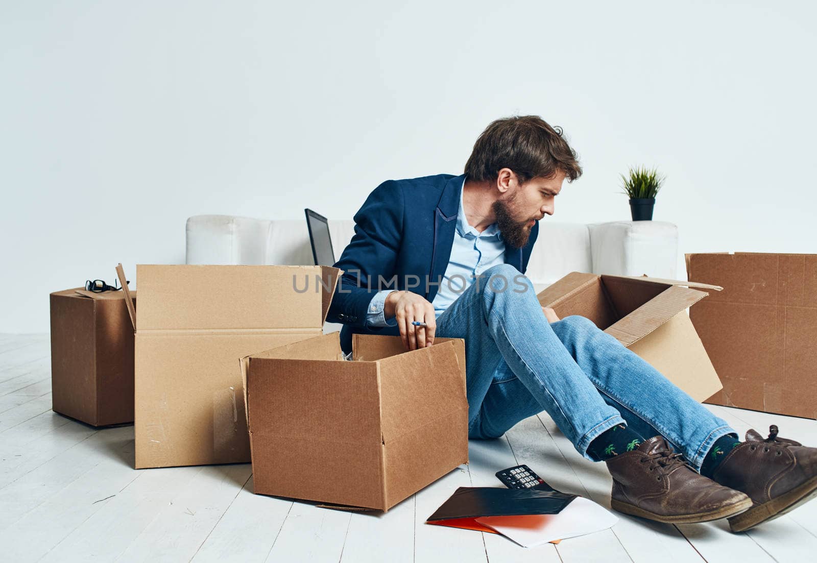 Business man picking up cardboard boxes and moving to a new place lifestyle by SHOTPRIME