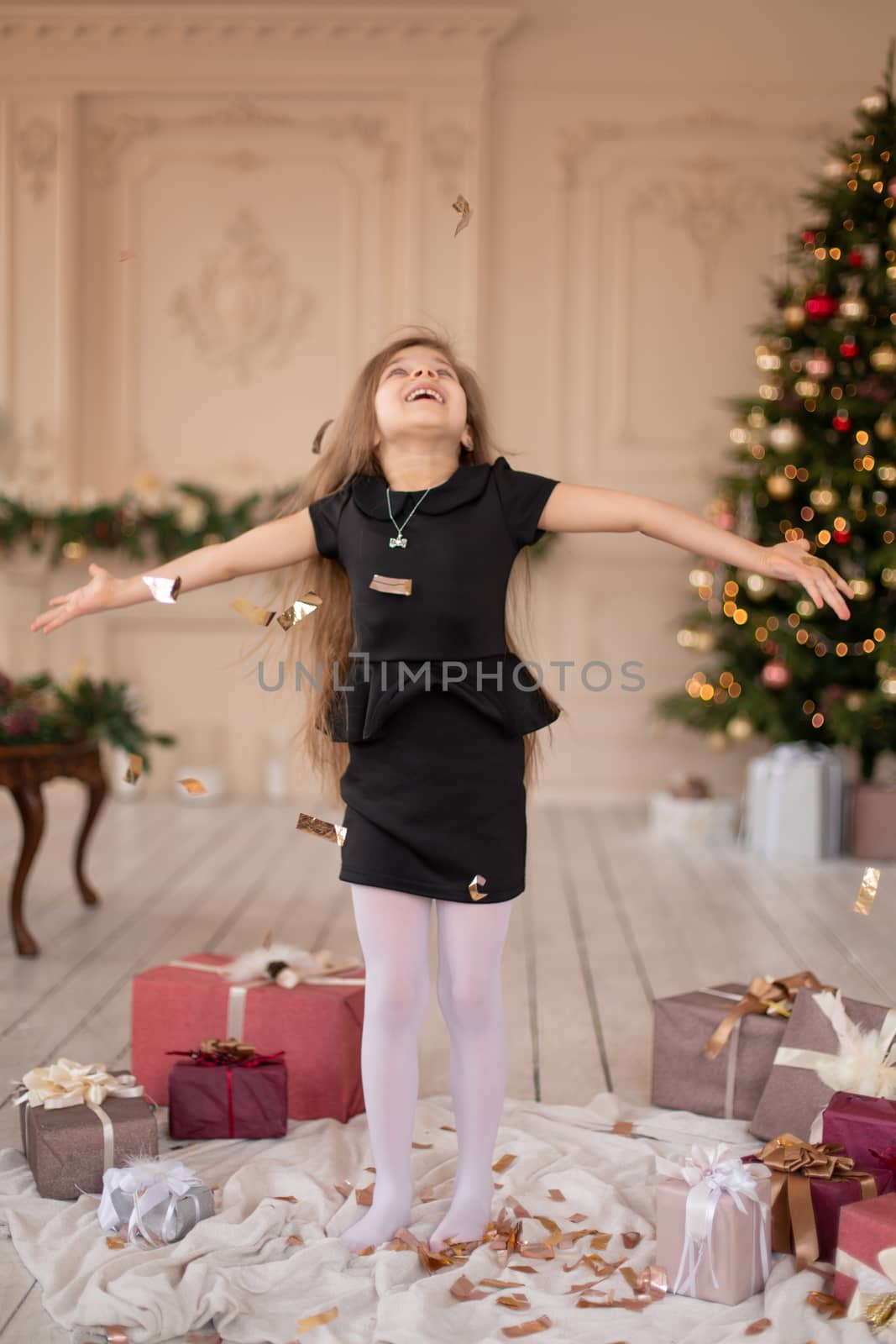 Little girl throws confetti. Christmas magic. Joyful moments of a happy childhood.