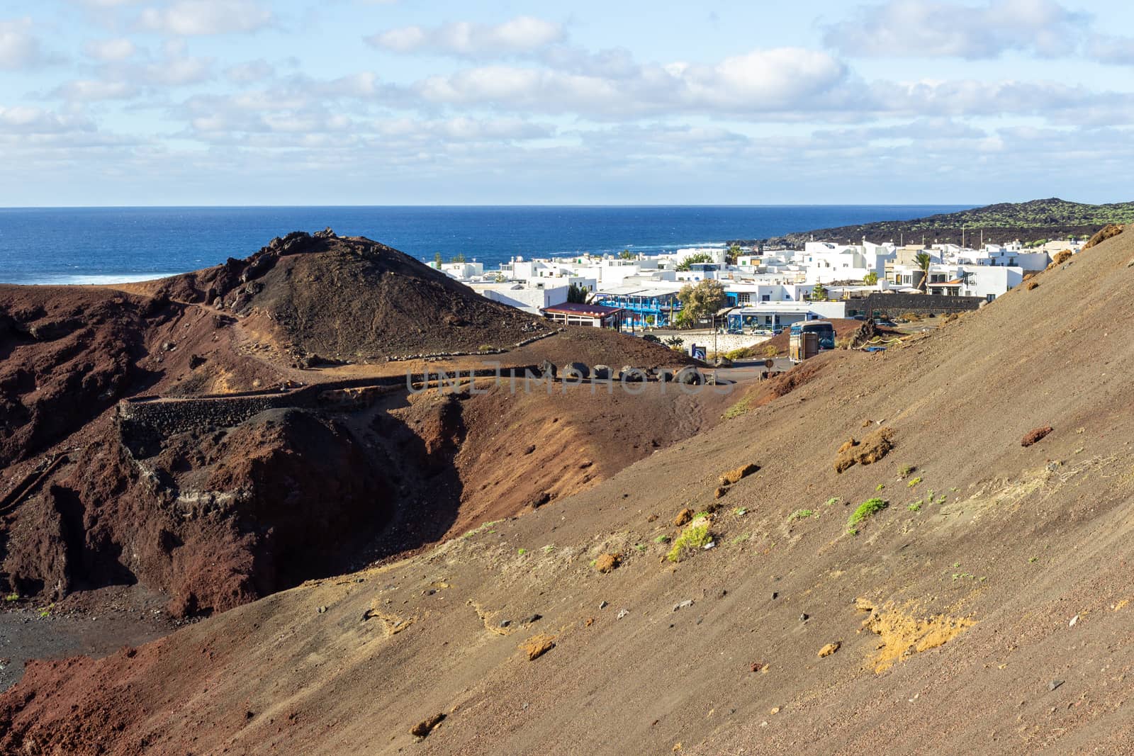 Panoramic view on the coastline of El Golfo with red and black colored volcanic rock formations and lava fields in the southwest of canary island Lanzarote
