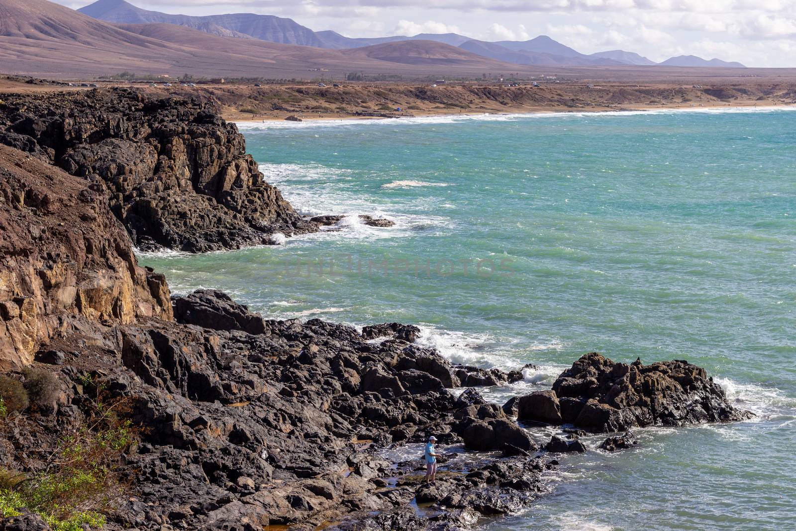 Panoramic view at the coastline of El Cotillo on canary island Fuerteventura, Spain with  lava rocks and mountain range in the  background