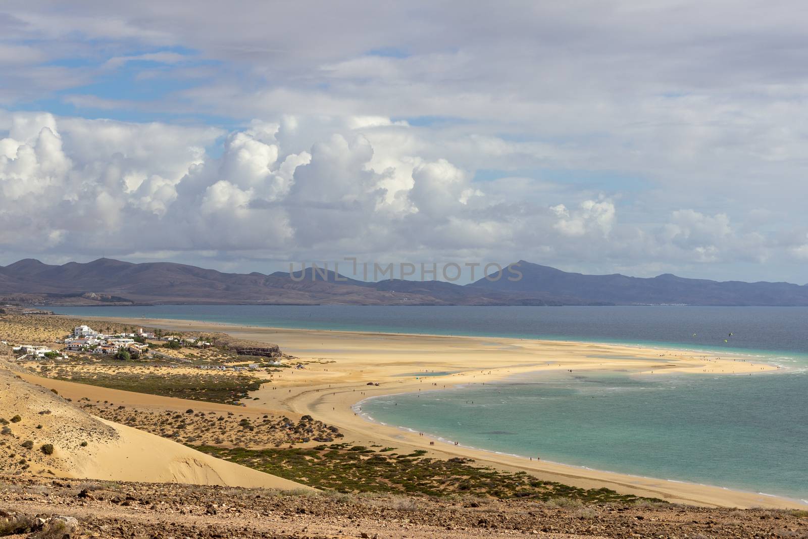 Panoramic view at sandy beach of Risco del Paso on canary island Fuerteventura, Spain  with  turquoise water and mountain range in the background