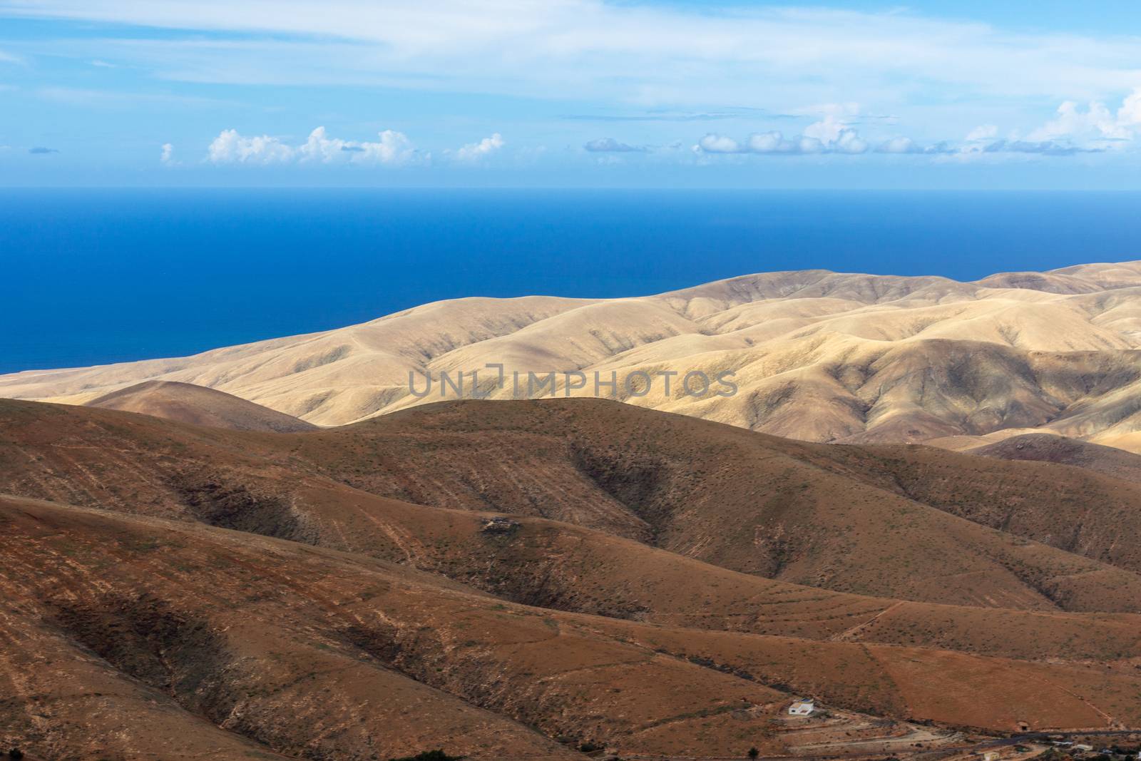 Panoramic view at landscape from viewpoint Mirador Morro Velosa on Fuerteventura, Spain with  multi colored volcanic mountainss and the Atlantic ocean in the background