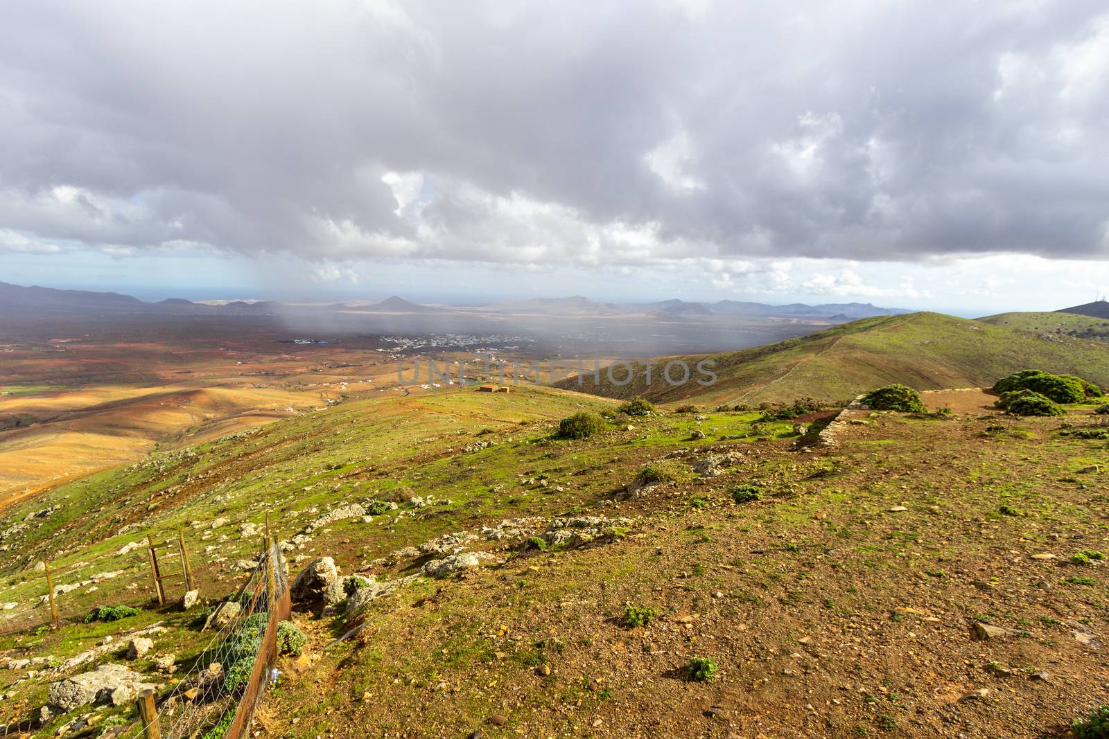 Panoramic view at landscape from viewpoint Mirador Morro Velosa on Fuerteventura, Spain with  green vegetation and multi colored volcanic hills