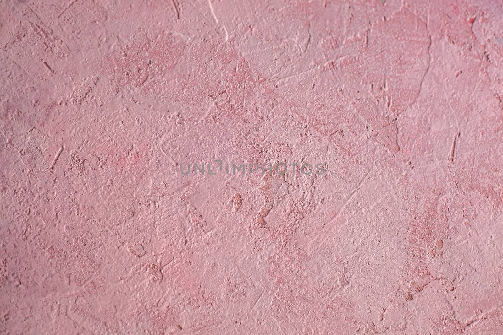 Concrete pink background with scuffs and splashes. Textured wall texture in the grunge style with soft focus. Space for text