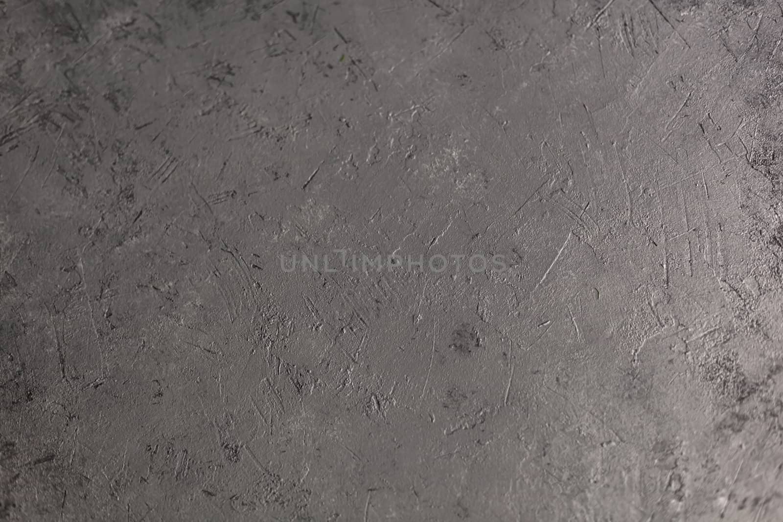 Concrete dark gray background with scuffs and splashes. Textured wall texture in the grunge style with soft focus. Space for text