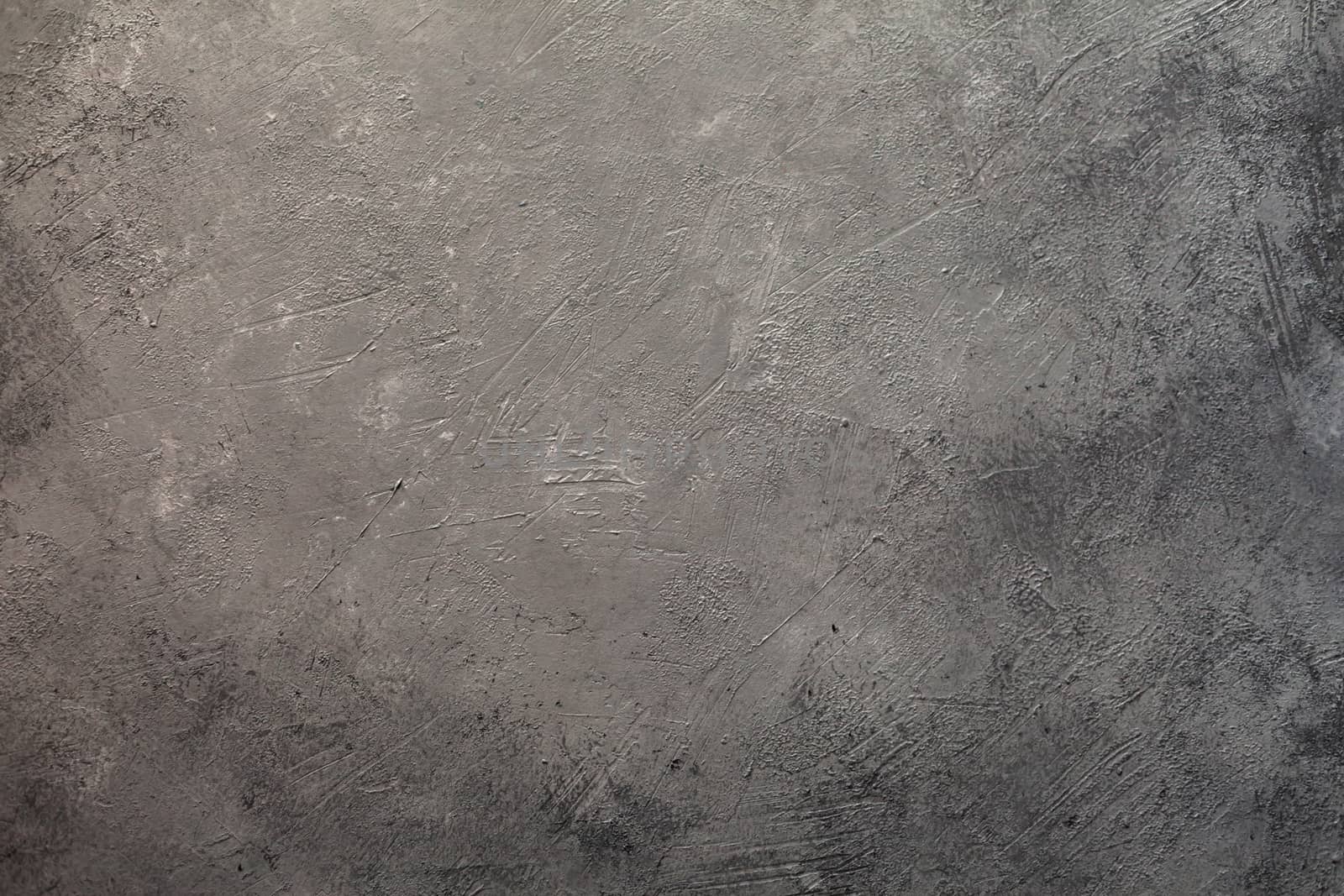 Concrete dark gray background with scuffs and splashes. Textured wall texture in the grunge style with soft focus. Space for text