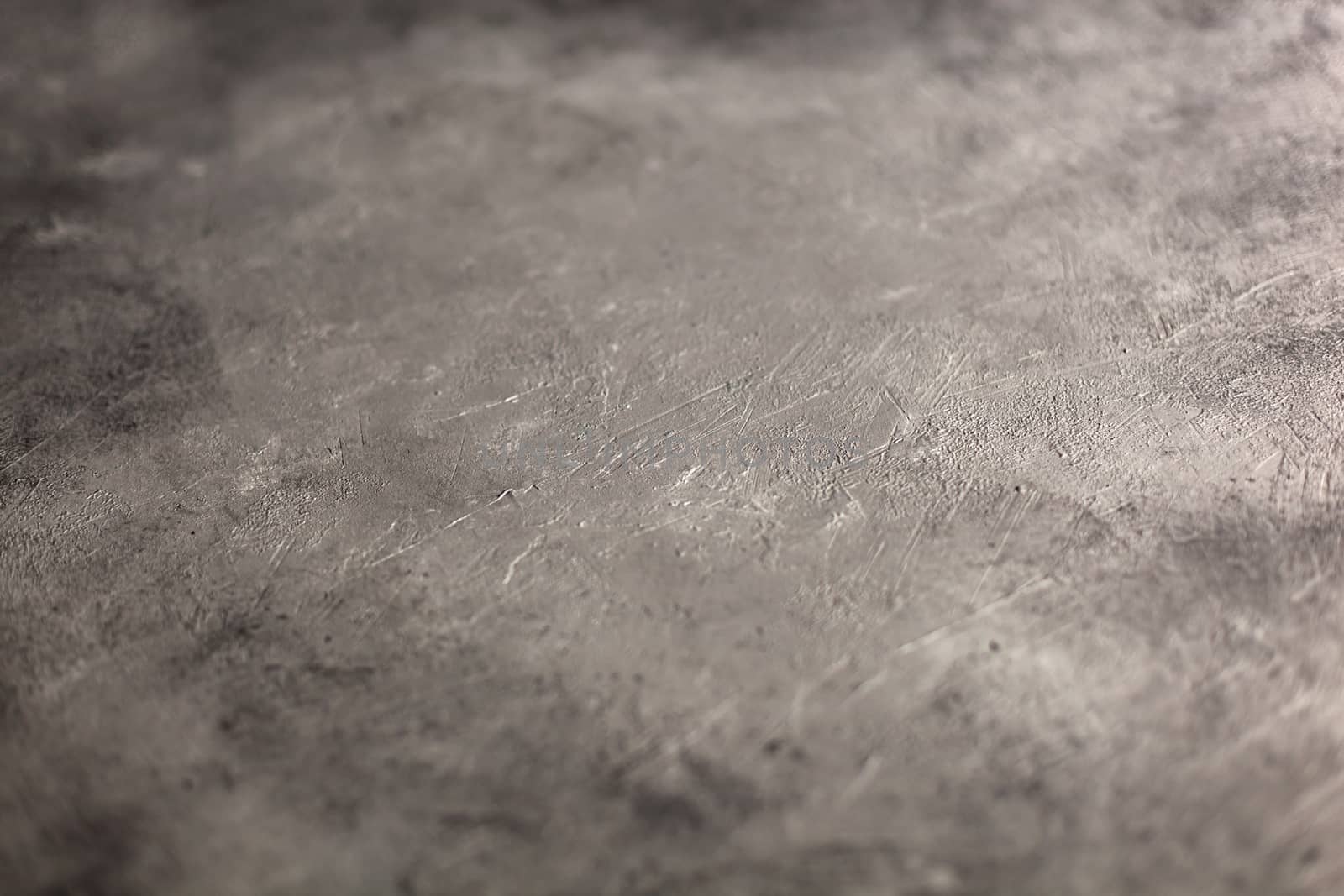 Concrete dark gray background with scuffs and splashes. Textured wall texture in the grunge style with soft focus. Space for text