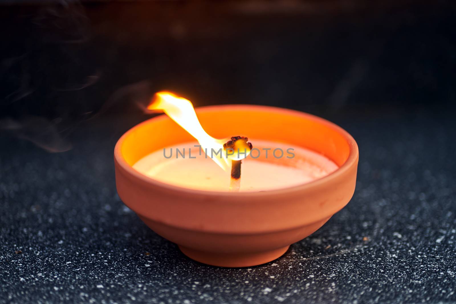 A candle burning on a grave in the cemetery of All Saints' Day in Poland