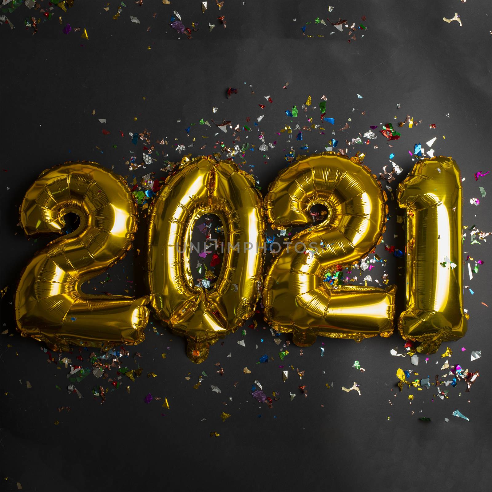 2021 new year concept from golden foil balloon and confetti on b by adamr