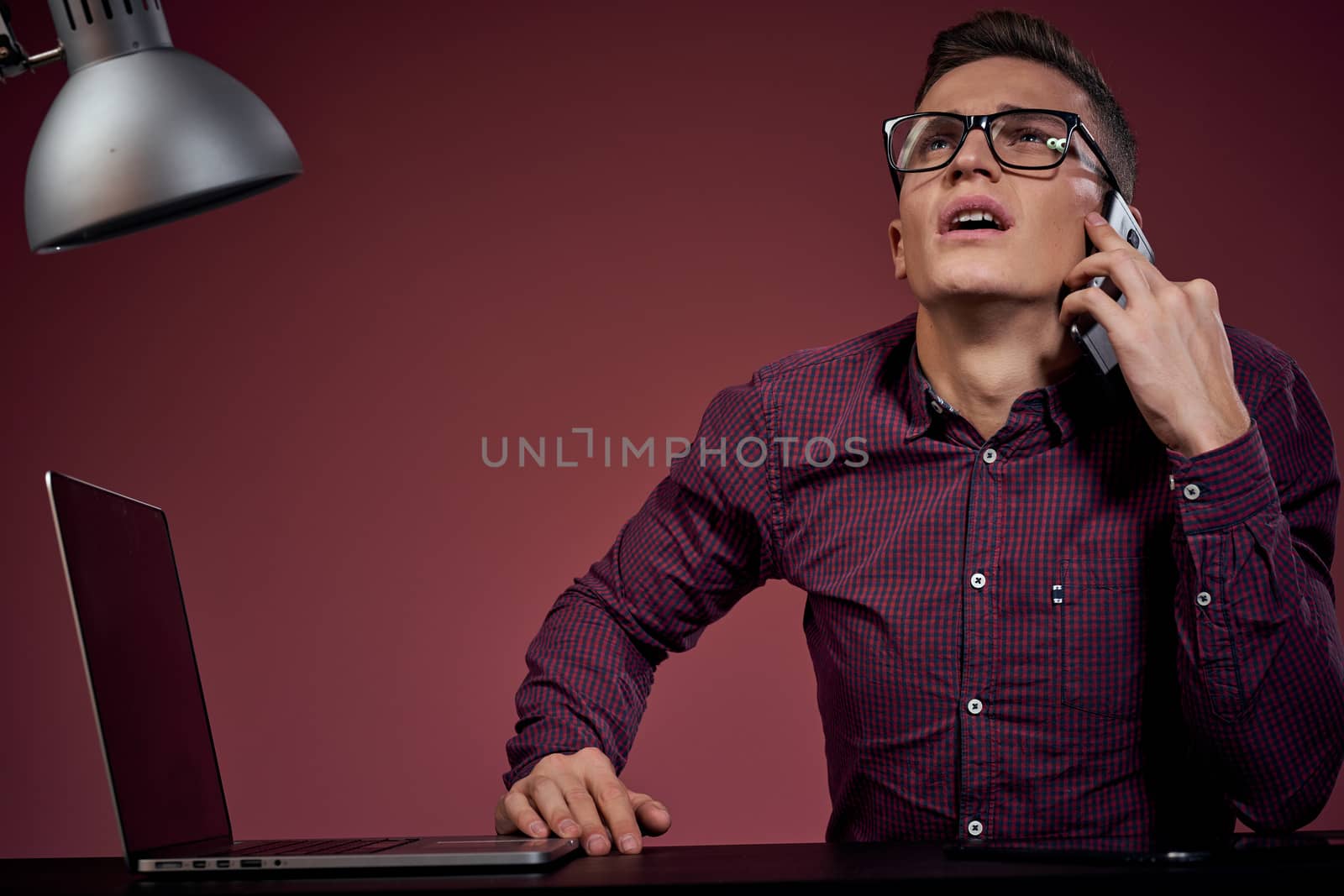 Business man in office and talking on the phone manager red background model cropped view of laptop tablet. High quality photo