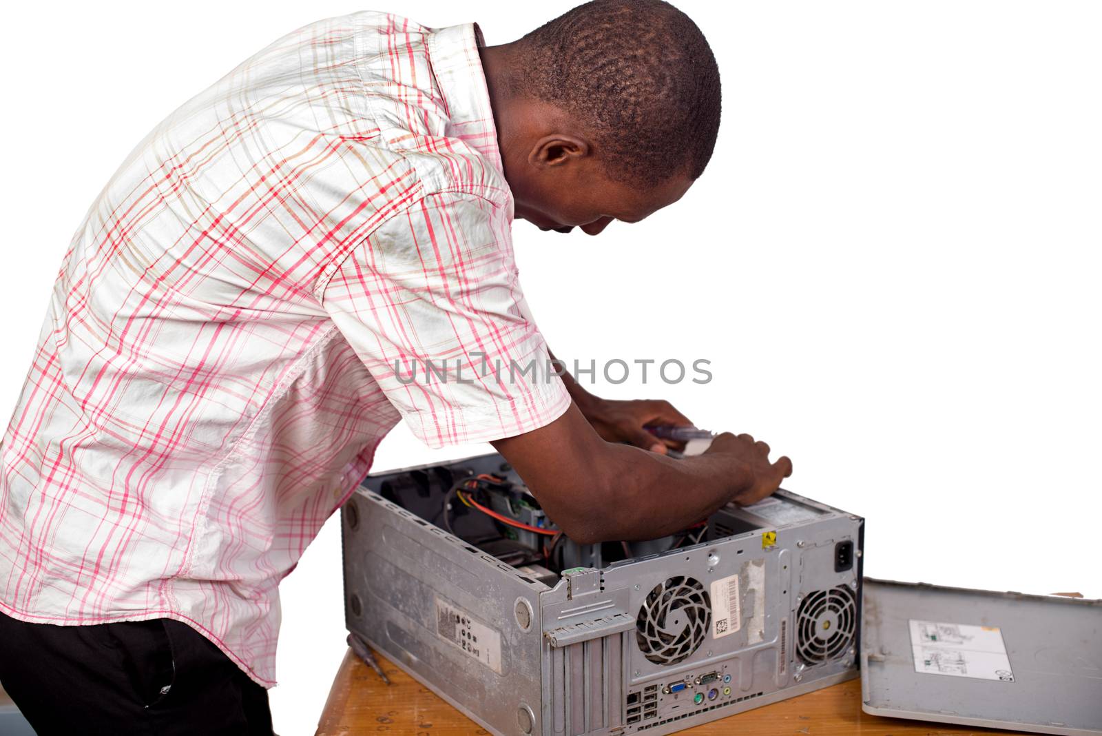 young technician standing over a desk repairing the computer