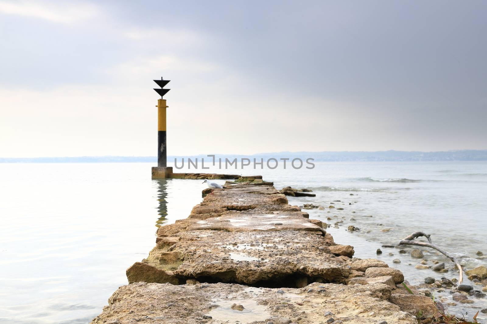 The view past a marker post across Lake Garda from the resort town of Sirmione in North East Italy.  Sirmione is at the southern end of the lake which is in North East Italy.
