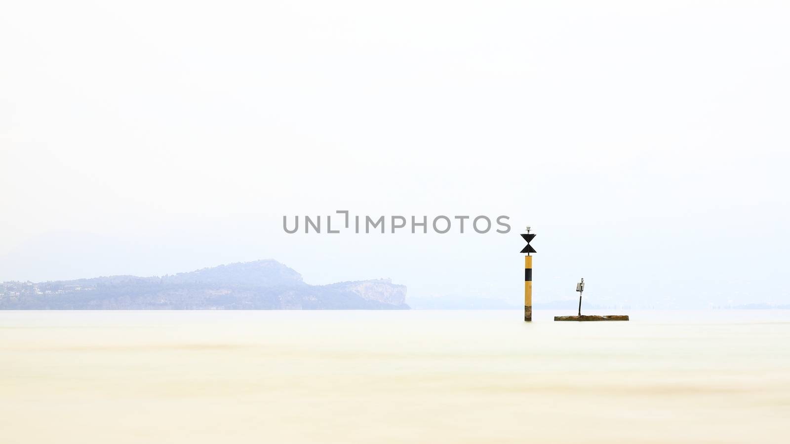 The view past a marker post across Lake Garda from the resort town of Sirmione.  Sirmione is at the southern end of the lake which is in North East Italy.