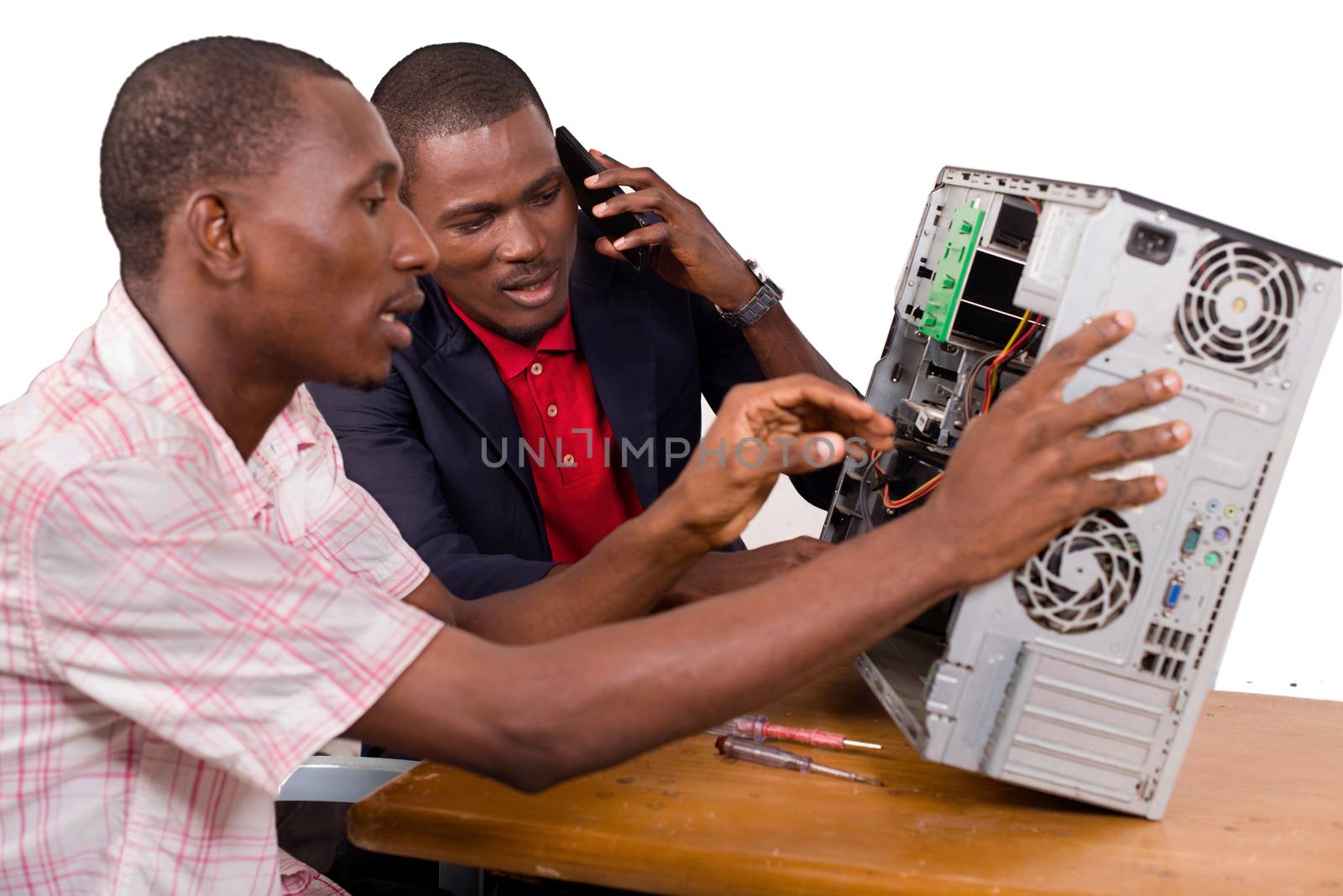 two technicians sitting at the desk working together on a computer