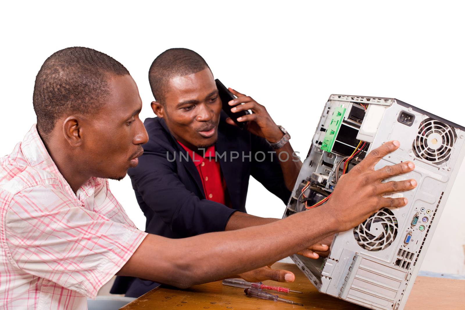 two technicians sitting at the desk working together on a computer