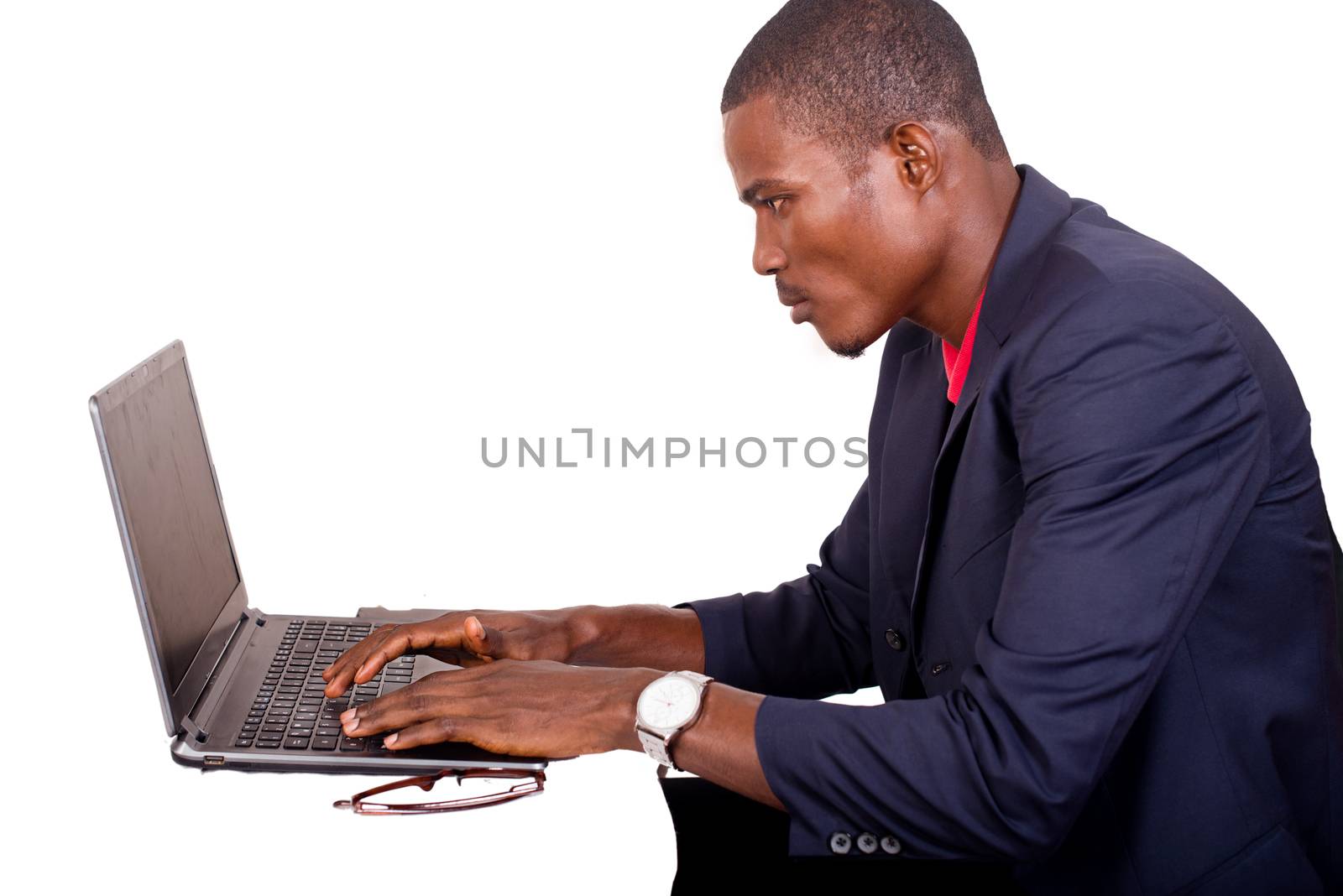 Young man working absorbed on laptop at work place.