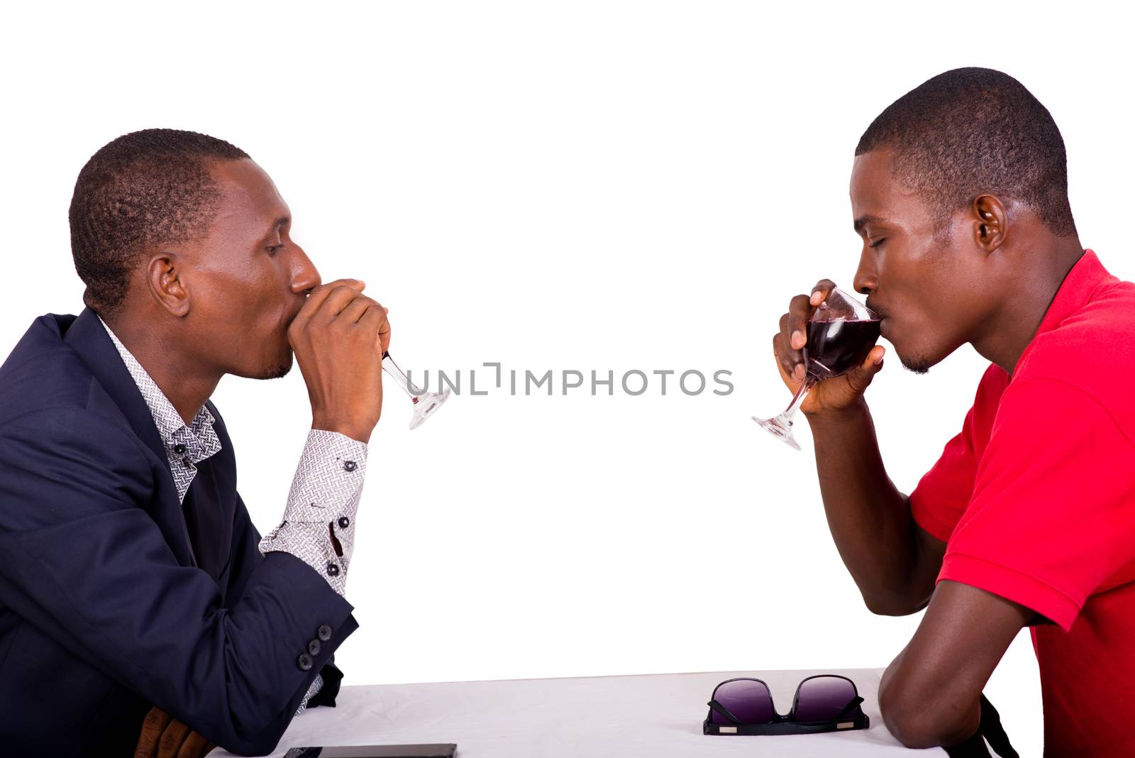 leisure and celebration, concept of smiling people drinking red wine at restaurant table on white background