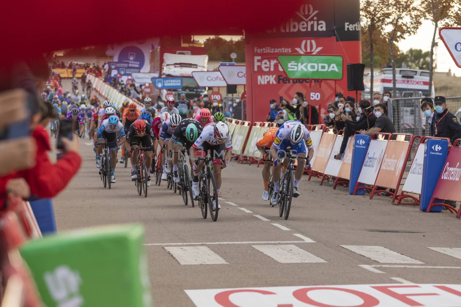 Cyclists from different teams, pedaling hard in the final sprint, in the area of the finish line of the fourth stage of La Vuelta a España 2020.