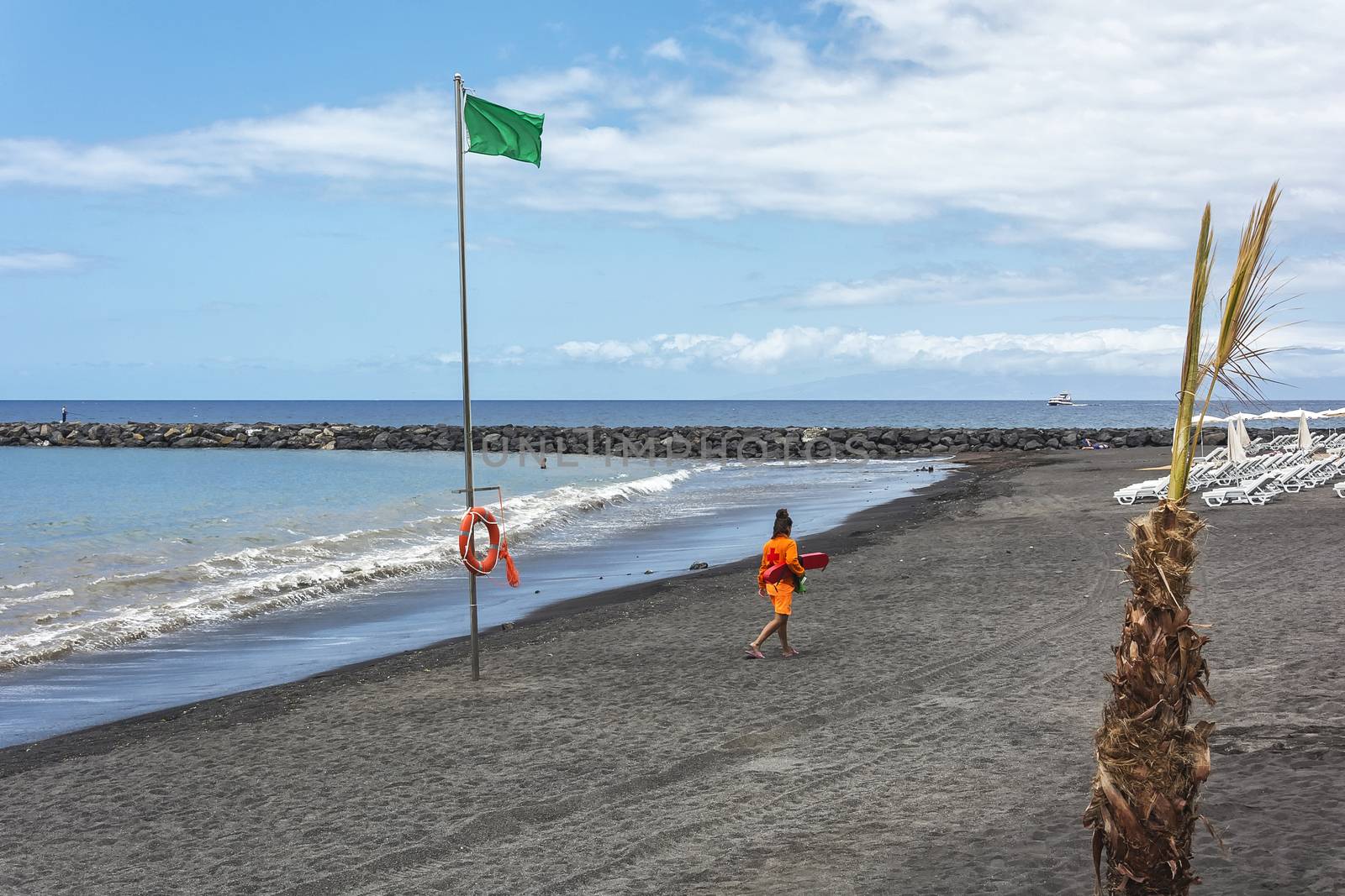 Spain, Tenerife - May 16, 2018: Green flag on the beach. On the shore is a lifeguard.