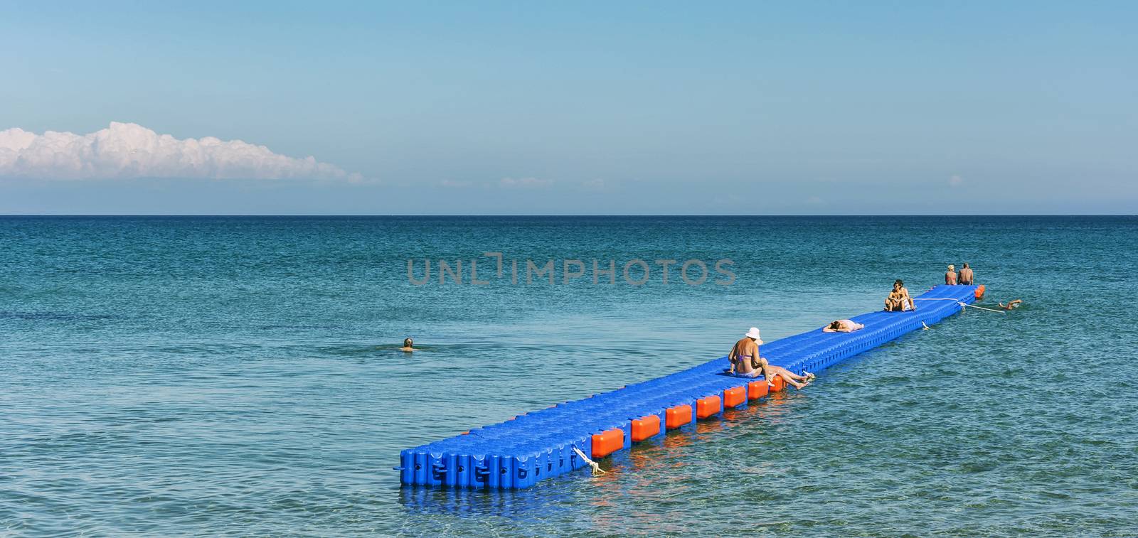 Zakynthos, Laganos - June 07, 2016: The pontoon jetty is installed in the sea. On the pontoon berth sunbathing vacationers