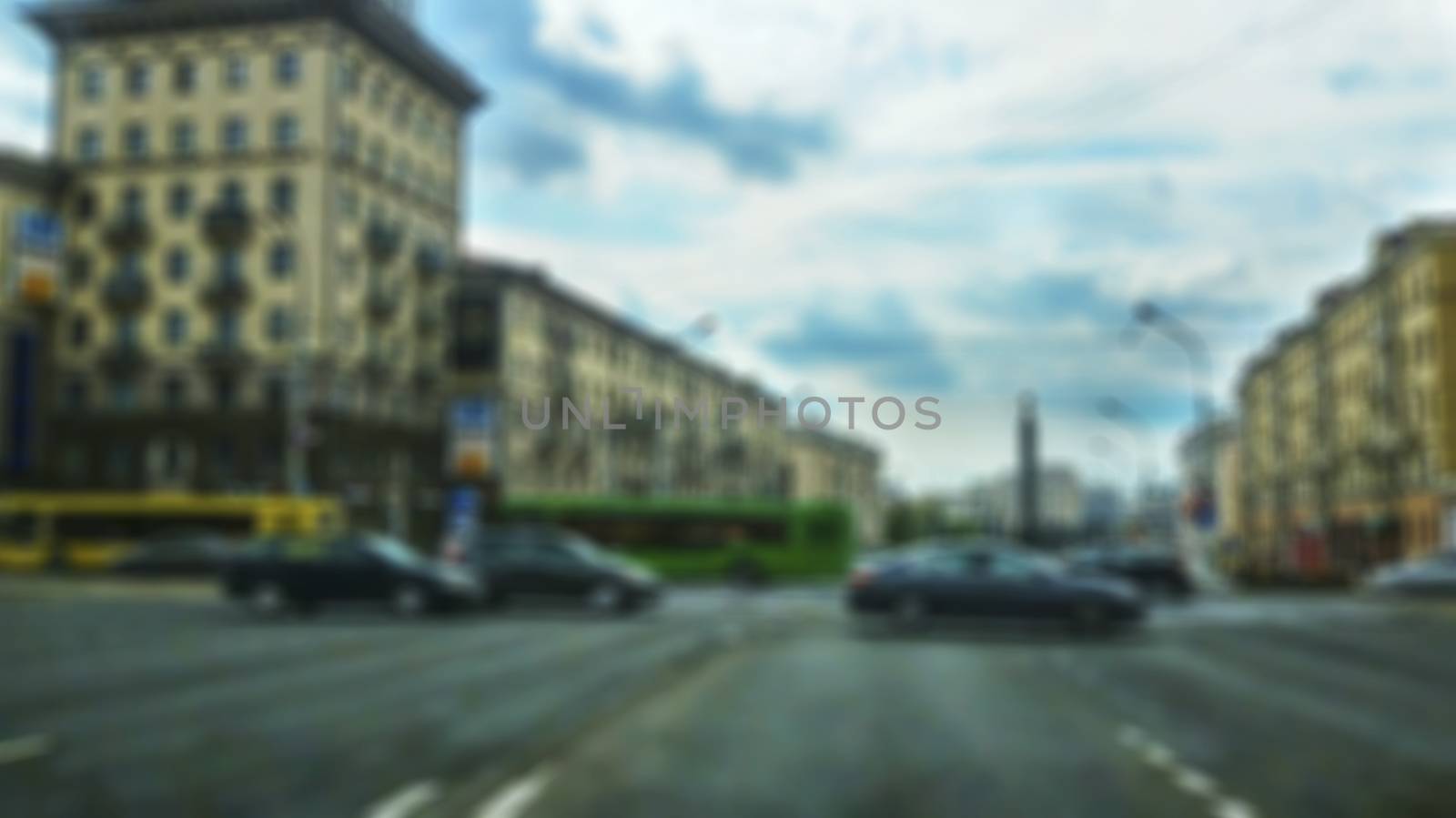 Perekrestok Avenue with moving vehicles in a creative story with a blurry surface image. View through car windshield