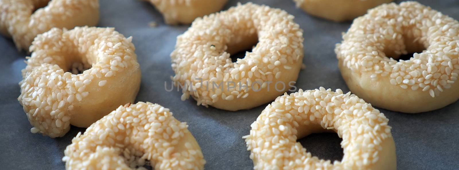 Close-up sesame seeds stuck to the dough, tiny bagels with sesame seeds,