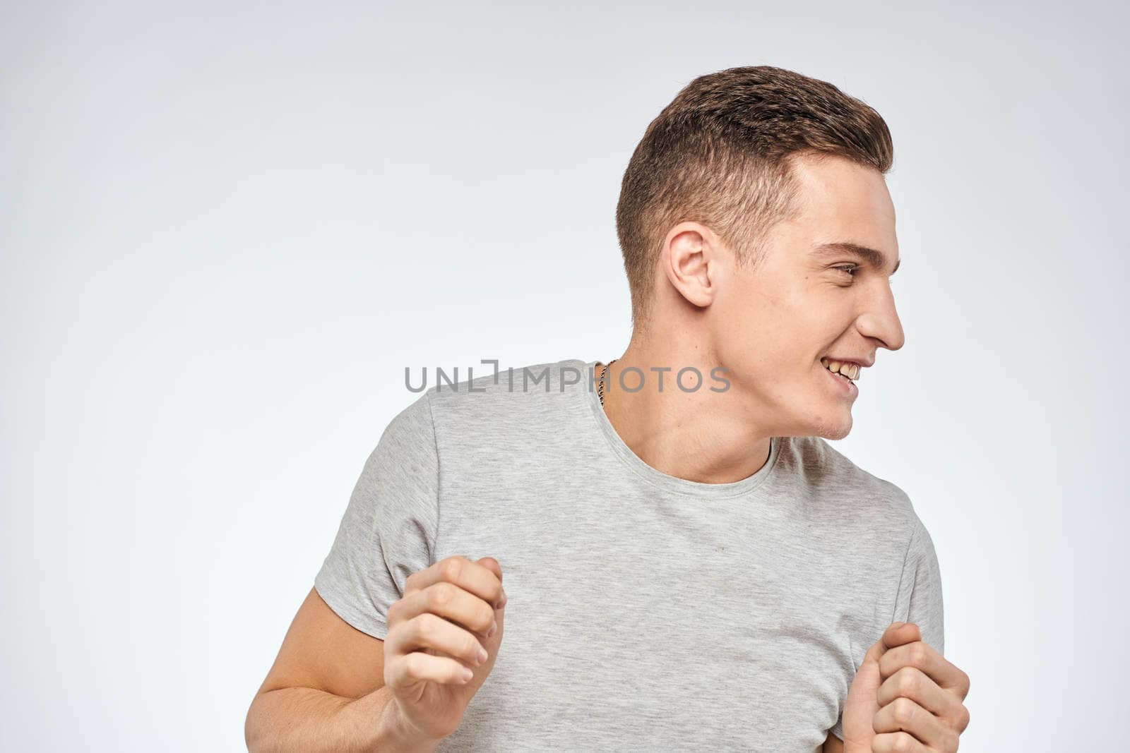man in gray t-shirt emotions light background cropped view. High quality photo
