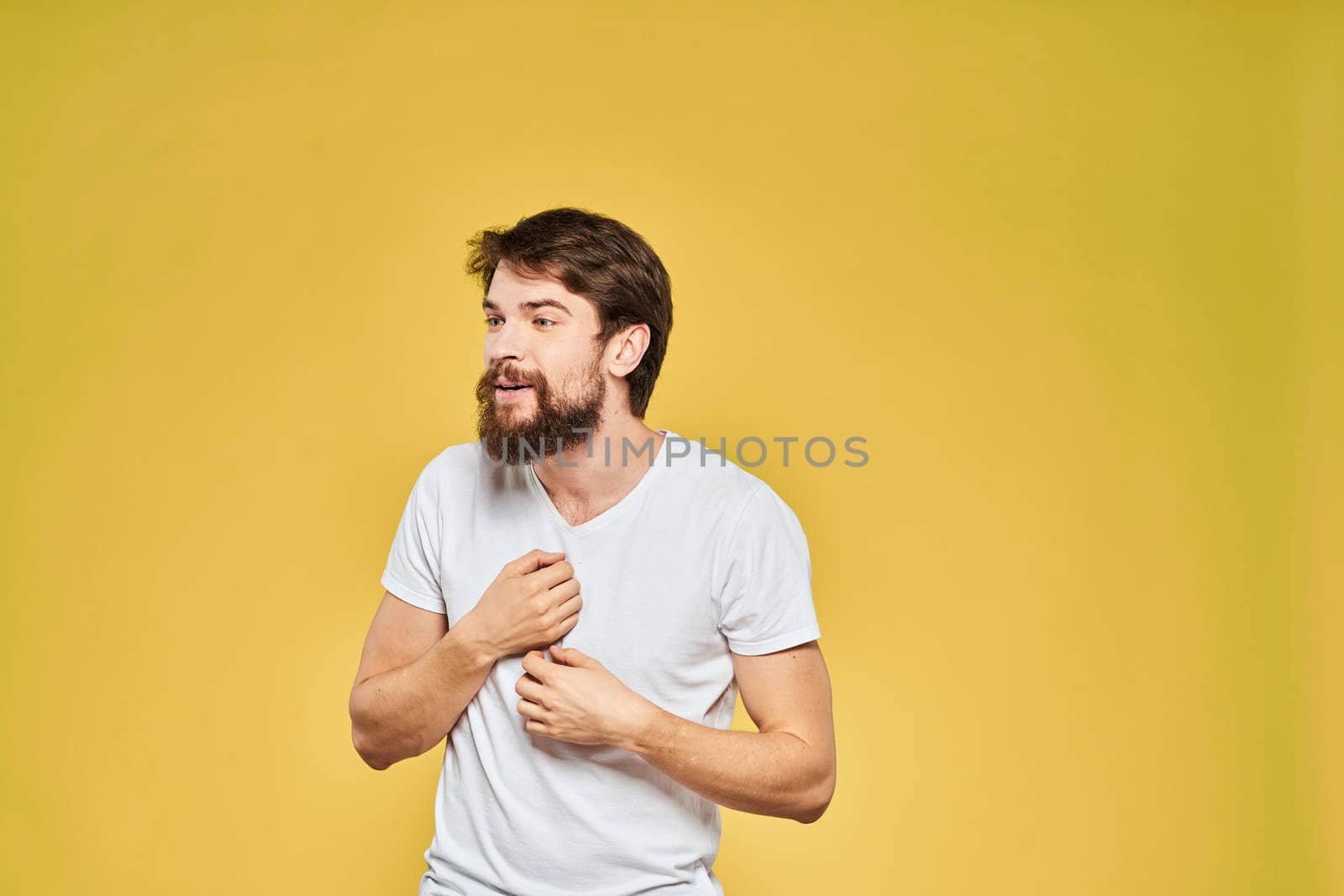 Bearded man in white t-shirt emotions close-up fun yellow background. High quality photo