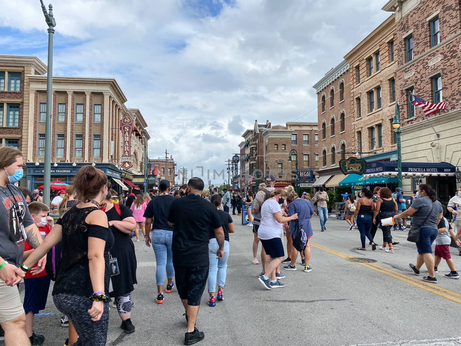 Orlando,FL/USA- 10/18/20: People walking around the busy Universal Studios  in Orlando, Florida while wearing face masks and social distancing.