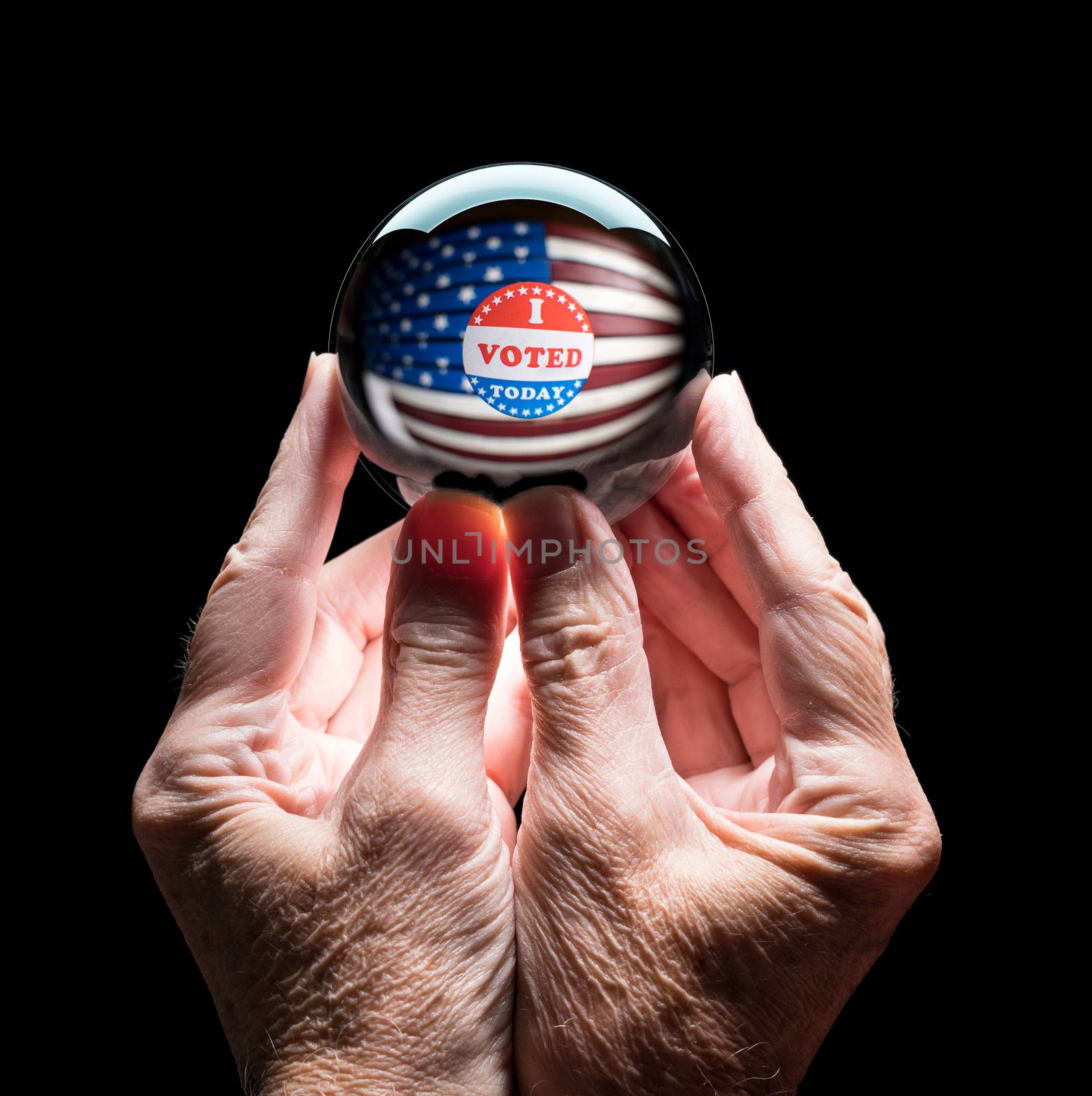 Hands holding a crystal glass forecasting ball to predict the result of the election by steheap